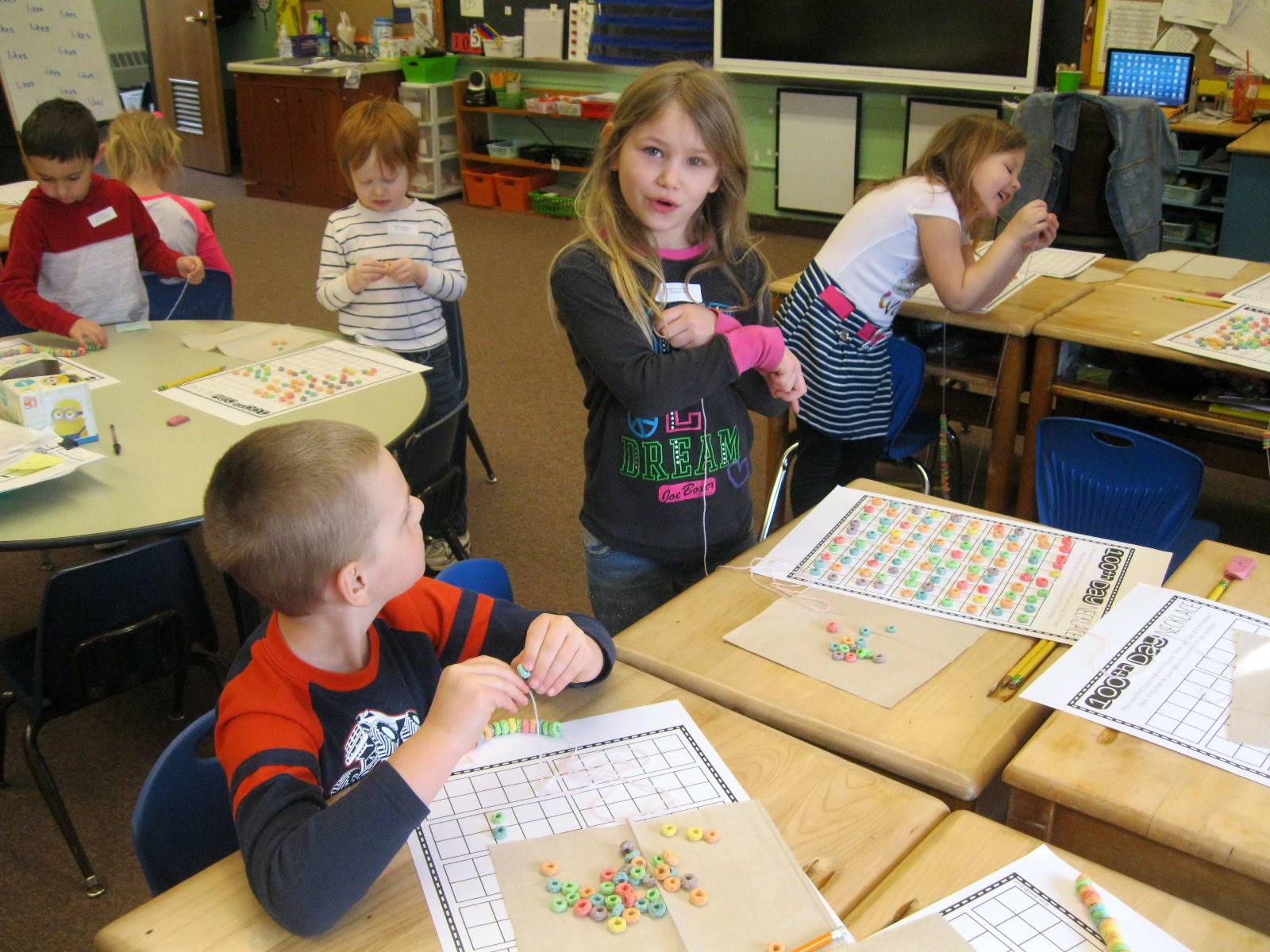 Students use 100 pieces of cereal to make a necklace.