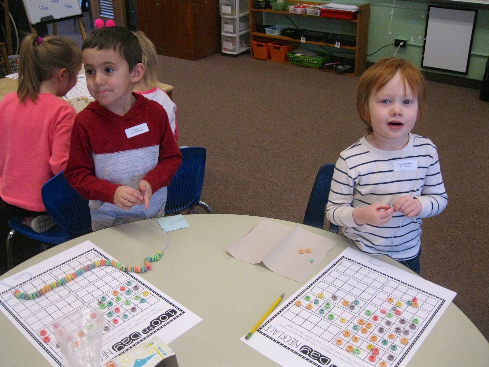 2 Students use 100 pieces of cereal to make a necklace.