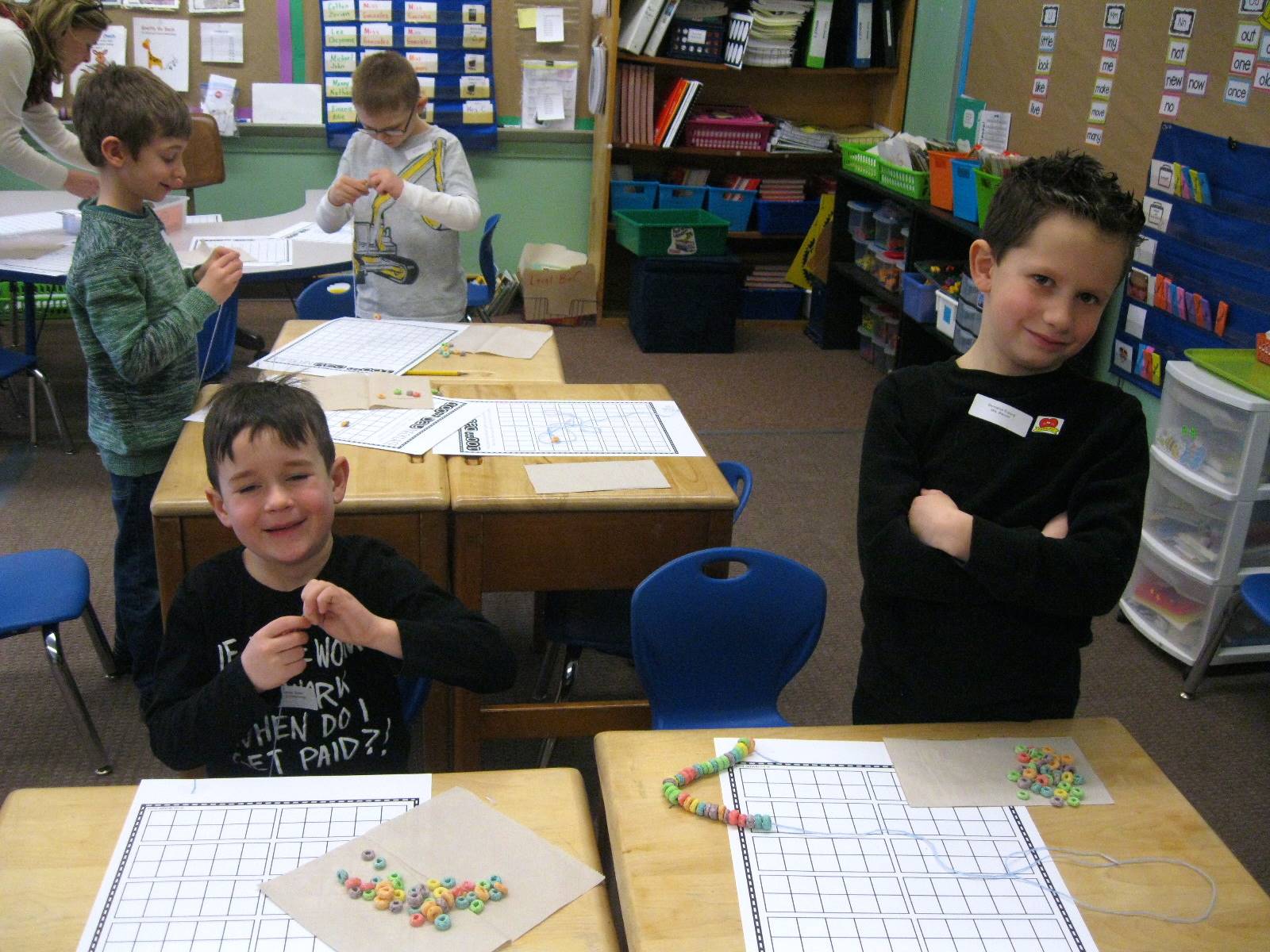 2 Students creating 100 piece necklaces.