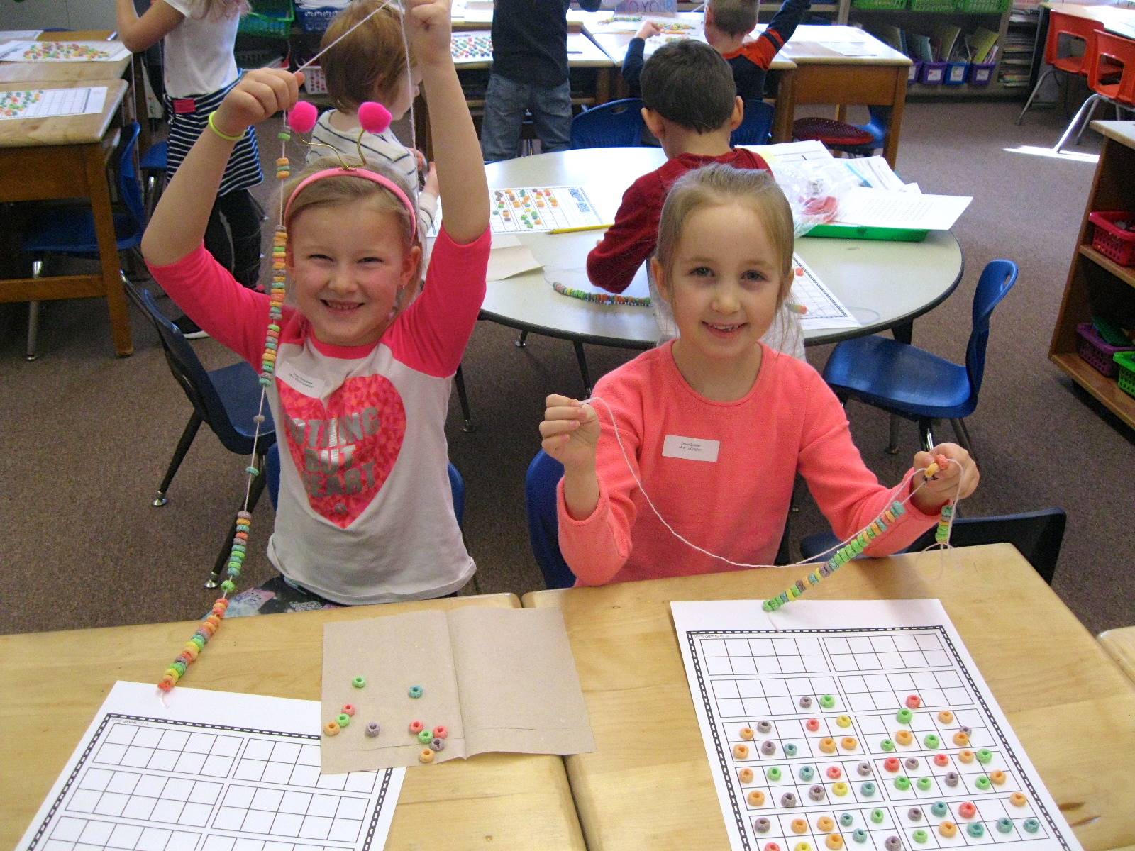 2 Students creating 100 piece necklaces.