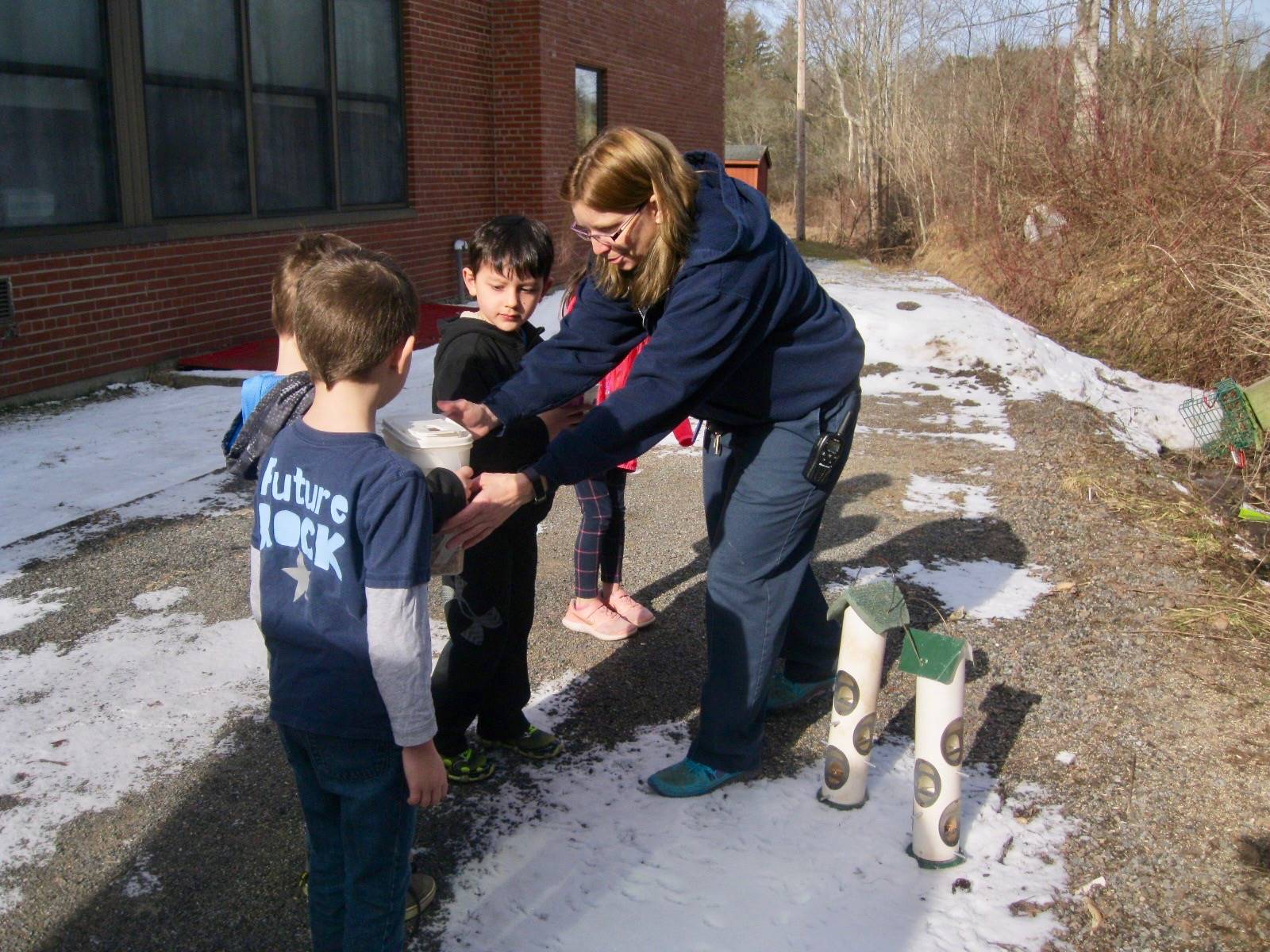 Miss Sonya and Kindergarten students feed the birds.