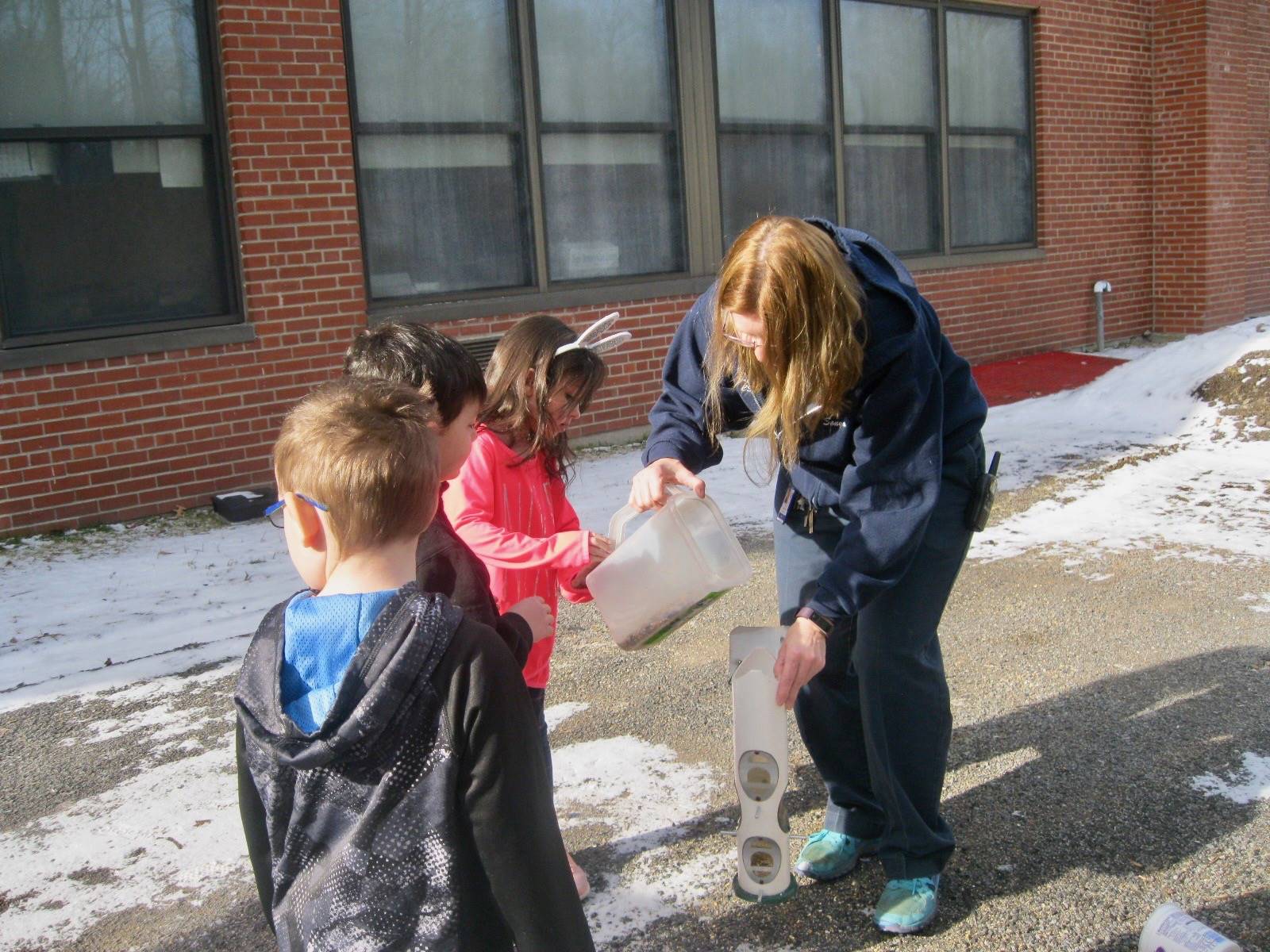 Miss Sonya and Kindergarten students feed the birds.