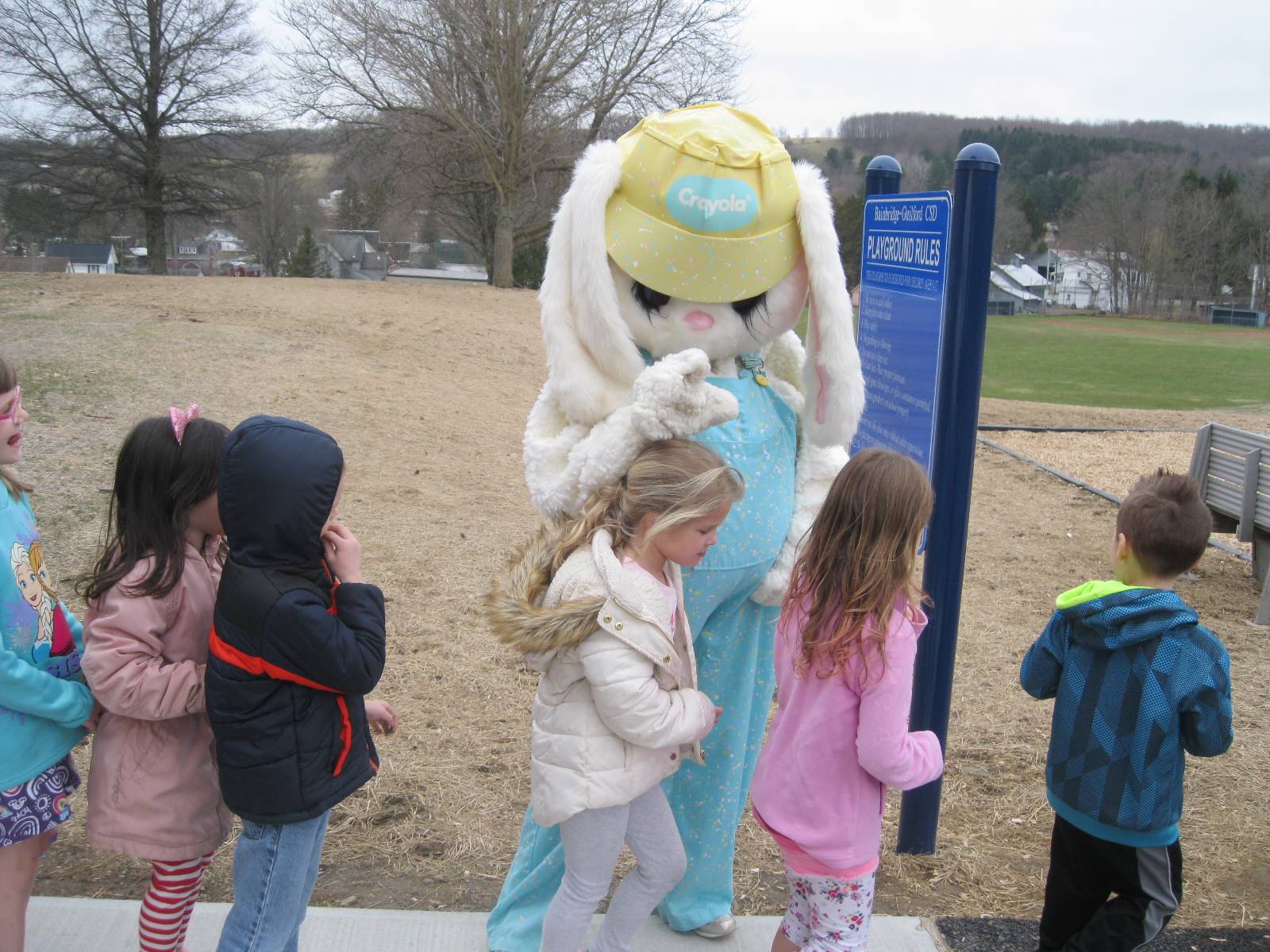 Easter bunny hugs students.