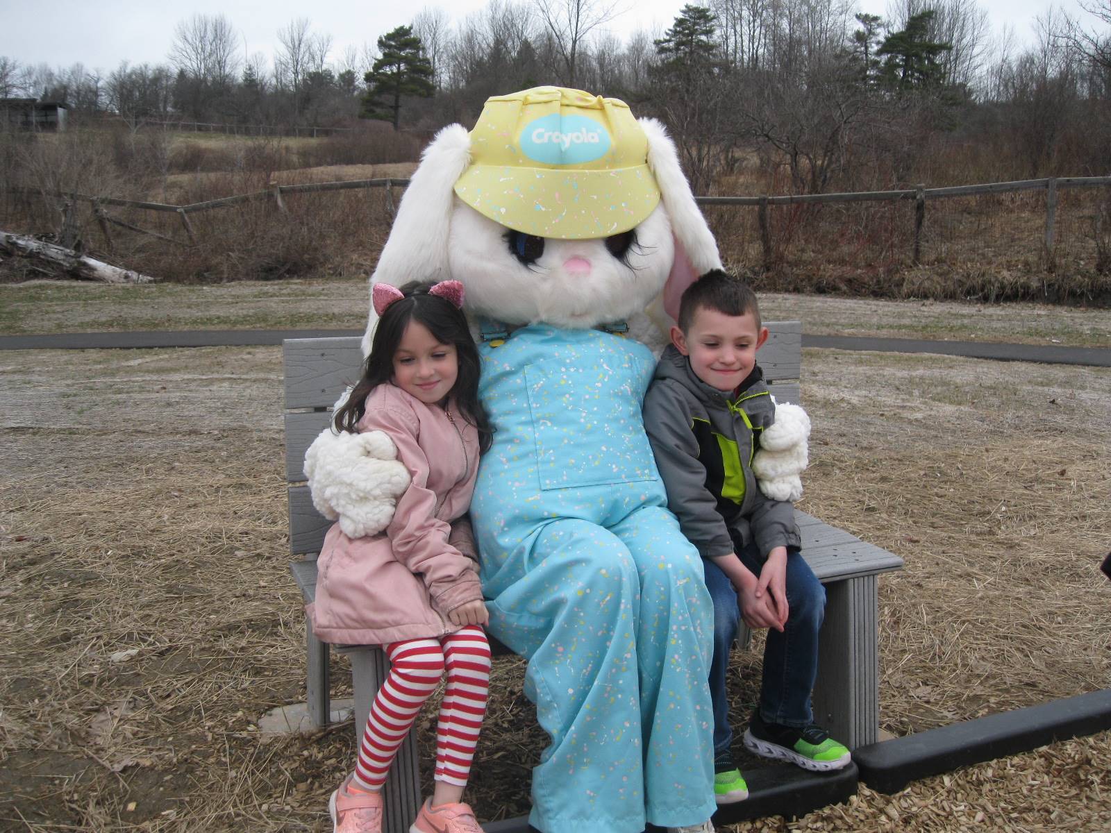 2 Students sit with Easter Bunny.