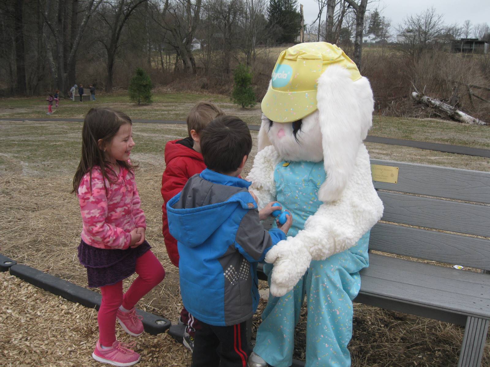 3 students "talk" with Easter Bunny.