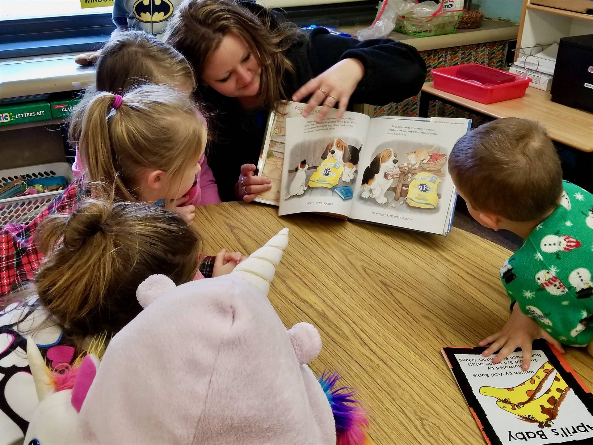 A parent reads a story to 5 students.