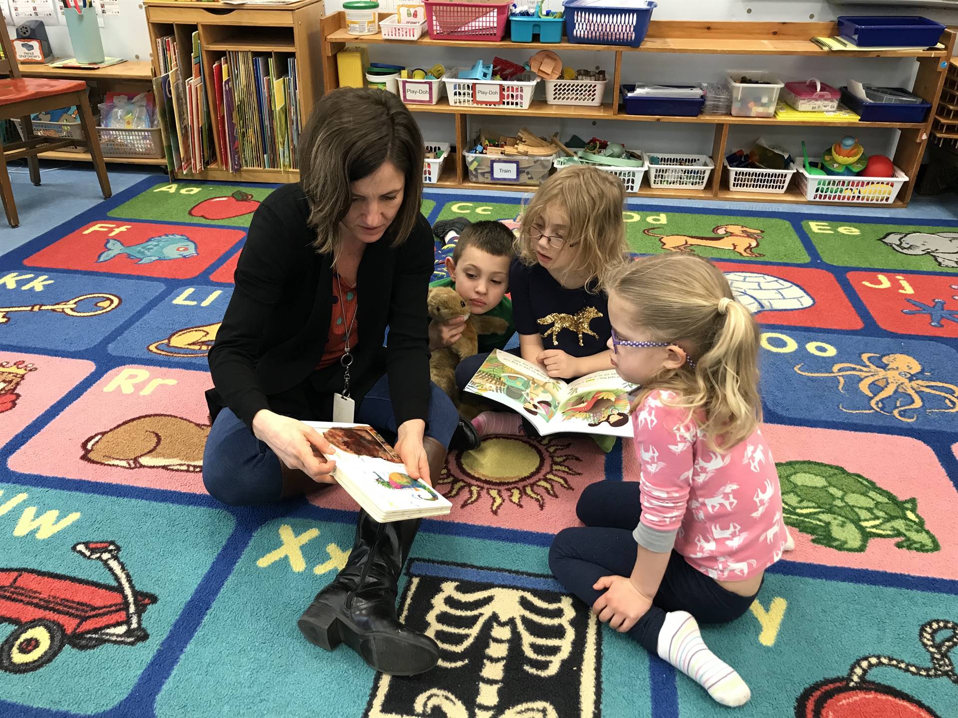Teacher reads with 3 students.