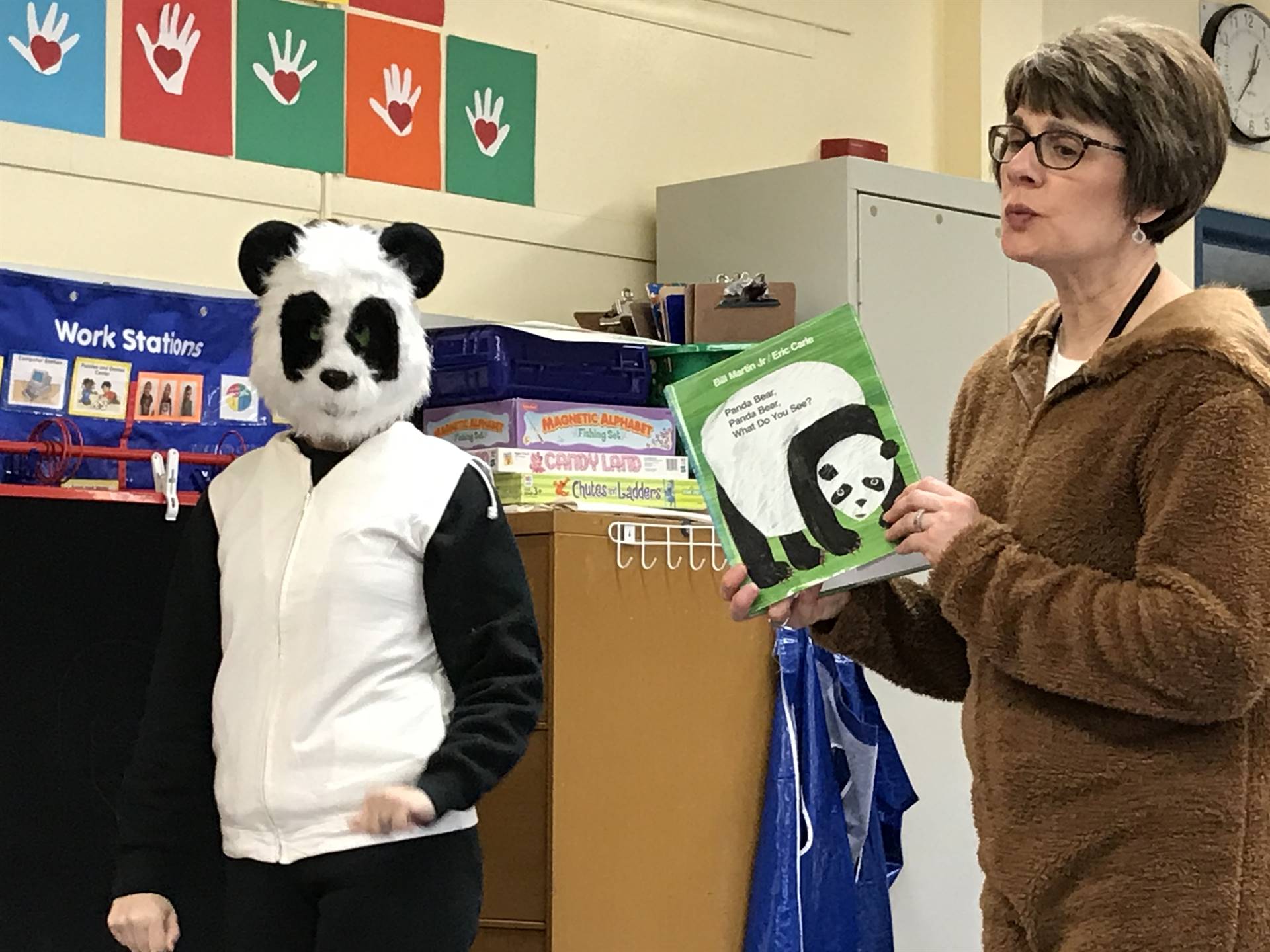 A panda and bear read a book.