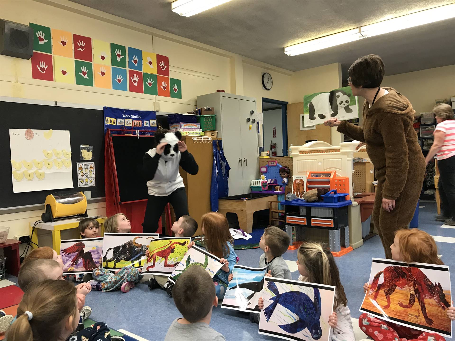 2 staff members dressed up read with pre k.