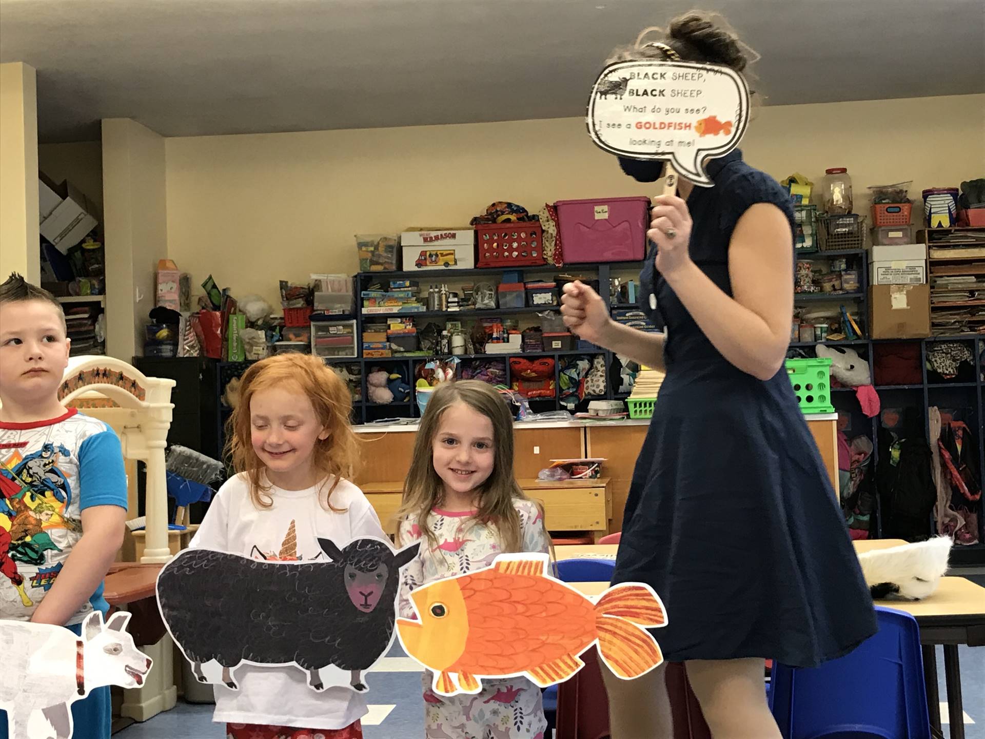 3 students act out a story with a staff member.