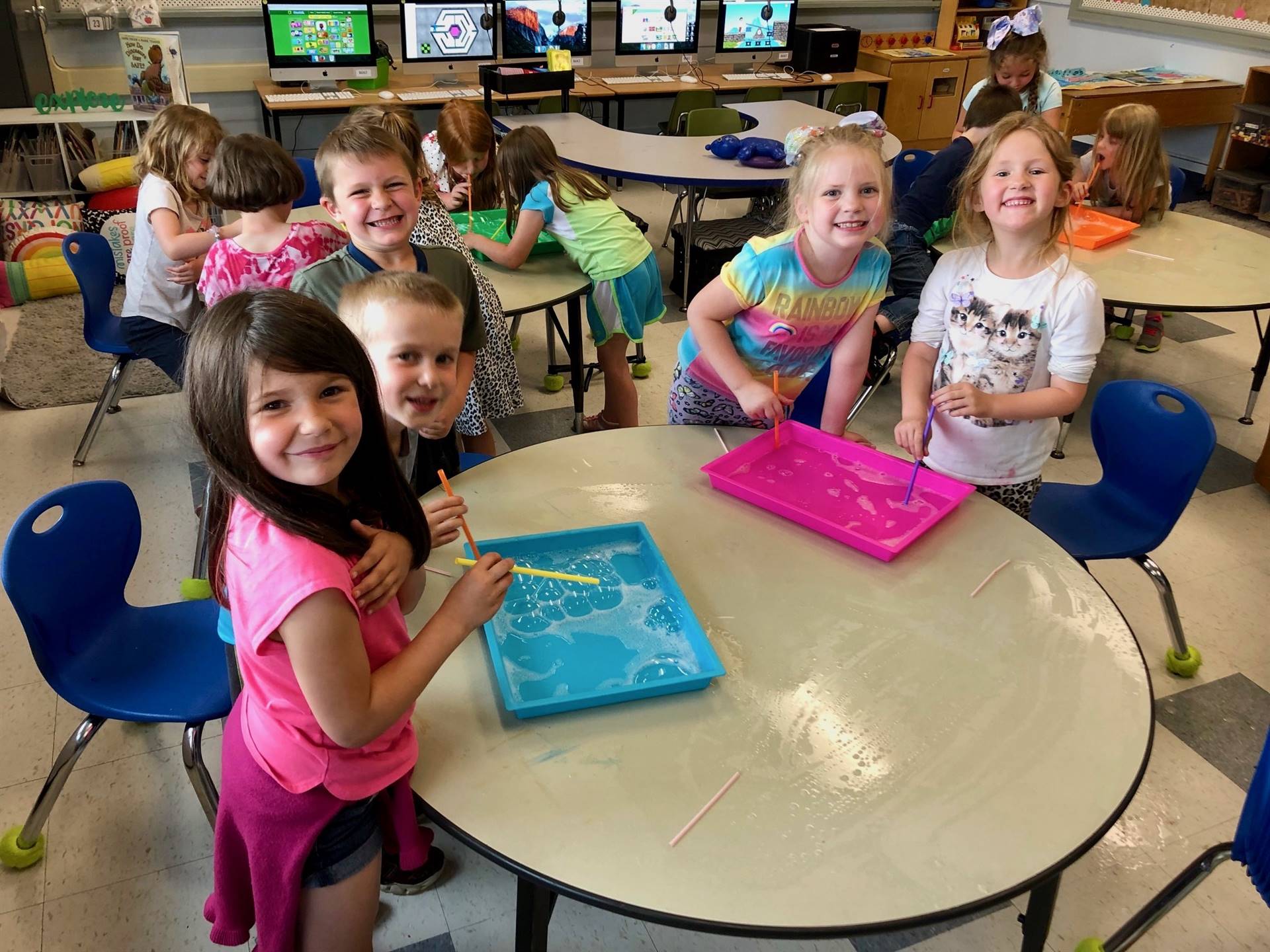 students experiment with straws, soap, and paint.