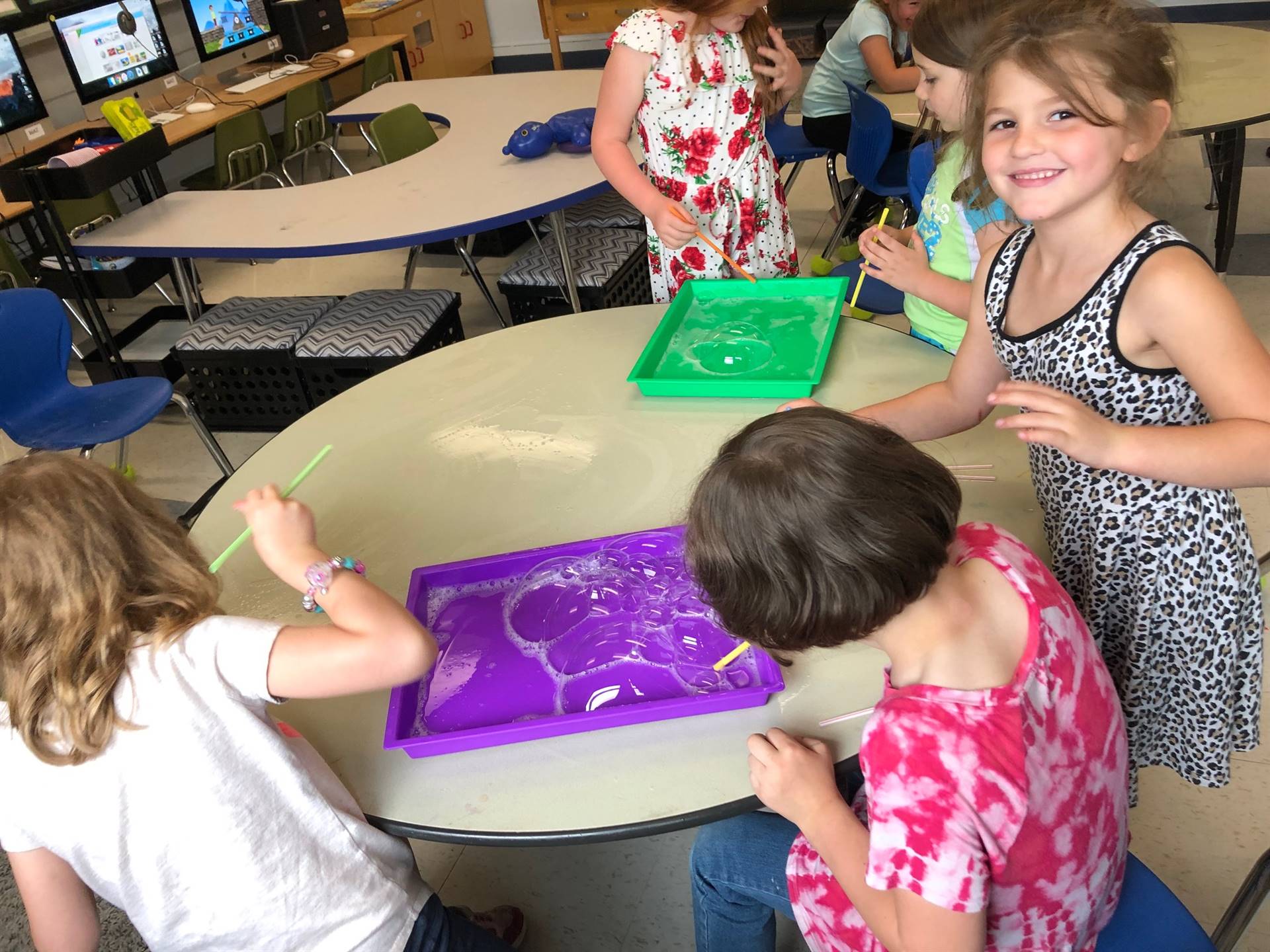 3 students show how bubbles mixed with paint looks.