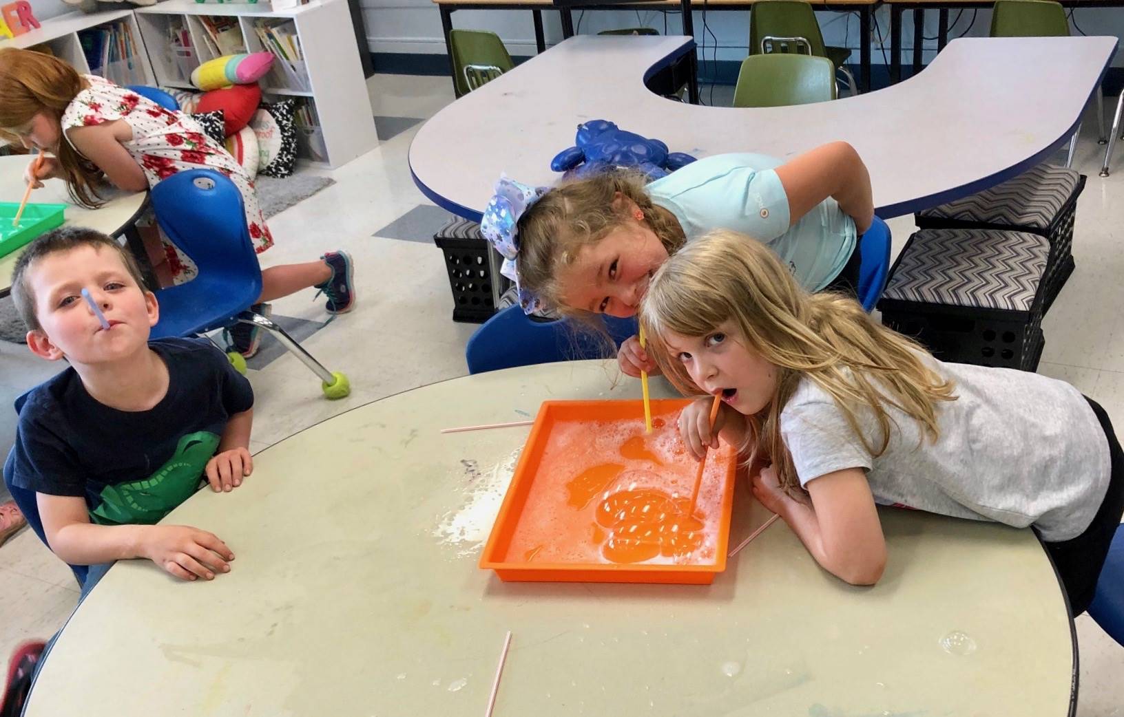 3 Students practice blowing bubbles.