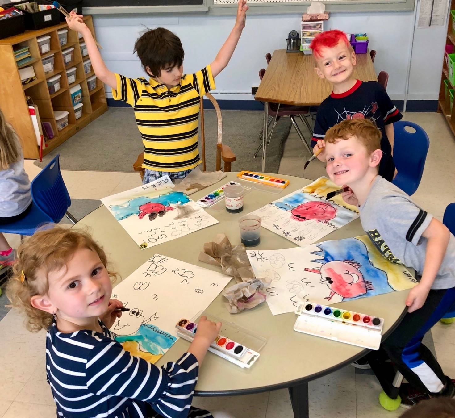 3 students show how bubbles mixed with paint looks.