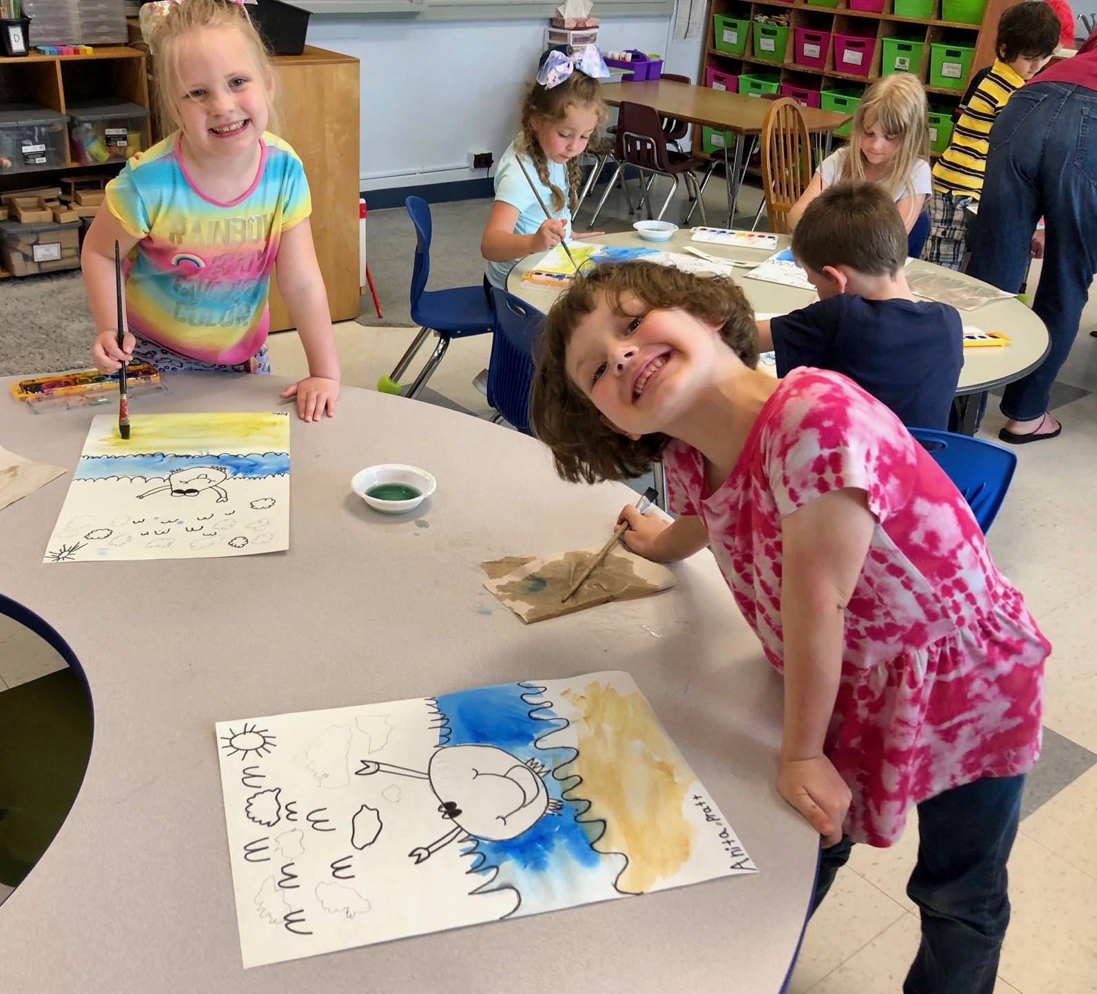 2 students show how bubbles mixed with paint looks.