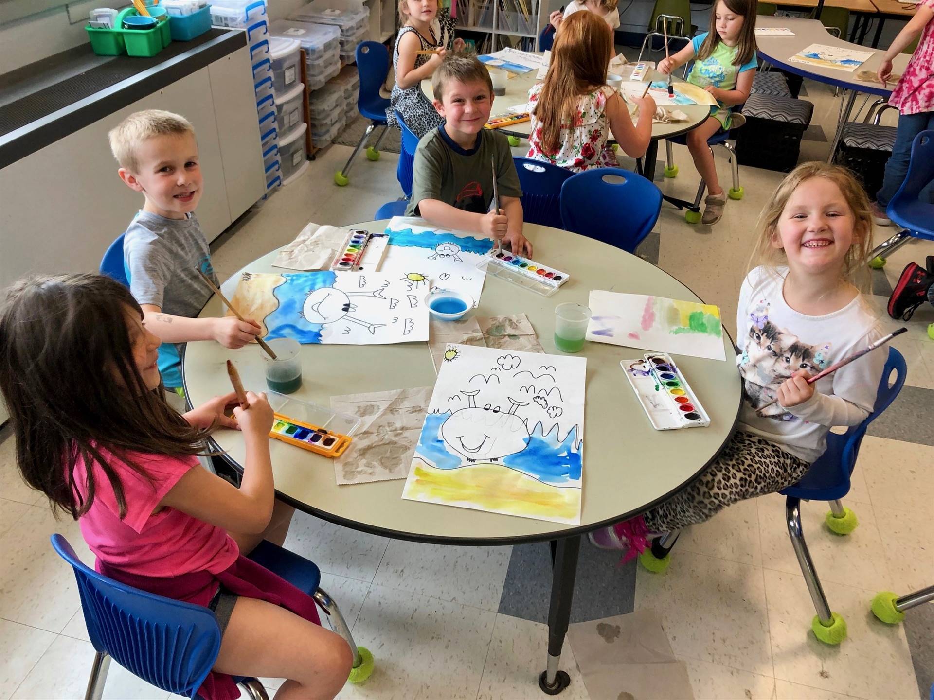 4 students show how bubbles mixed with paint looks.