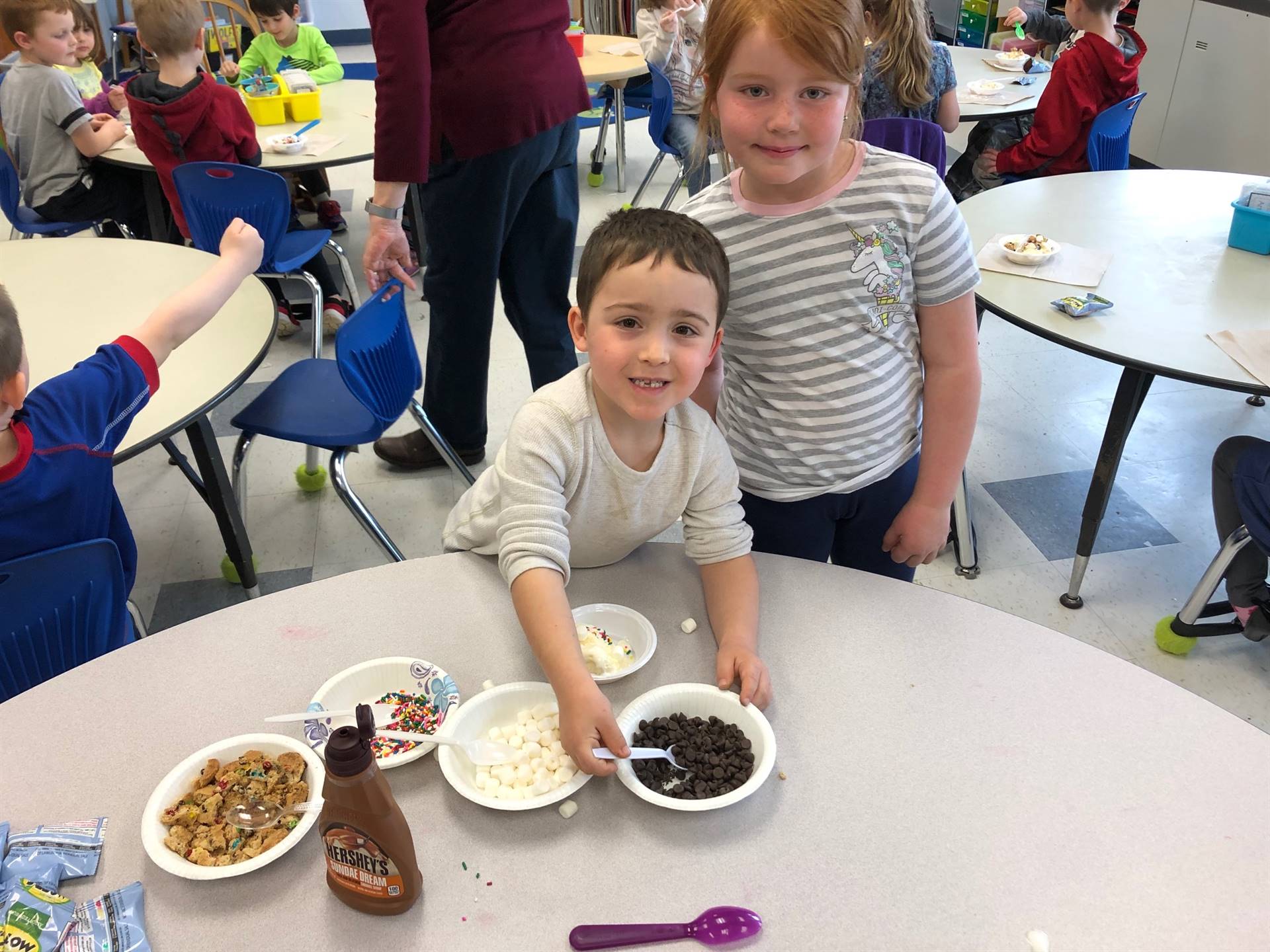 2 students choose toppings for their ice cream party