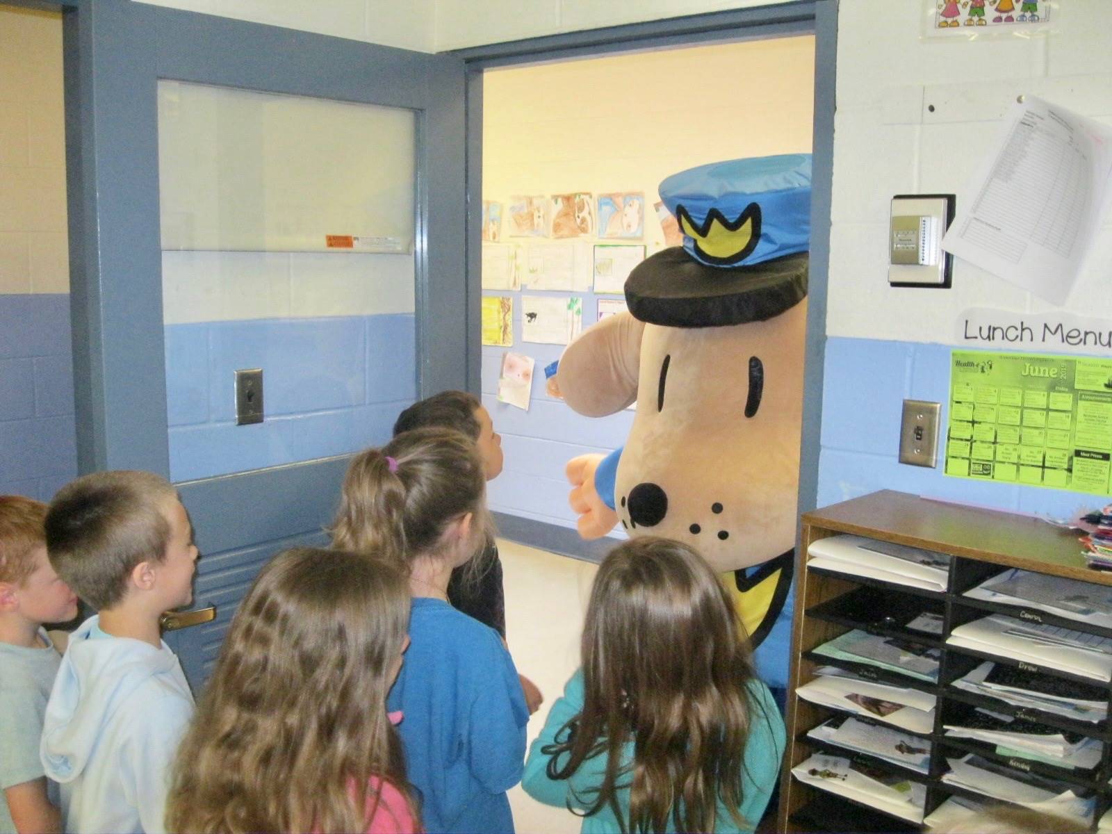 Dogman peeks through a door at students.