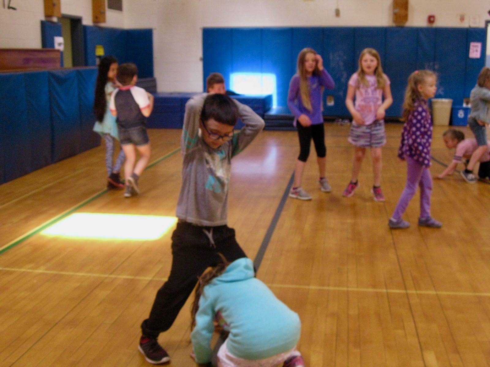 A student helps another be free during mud tag.