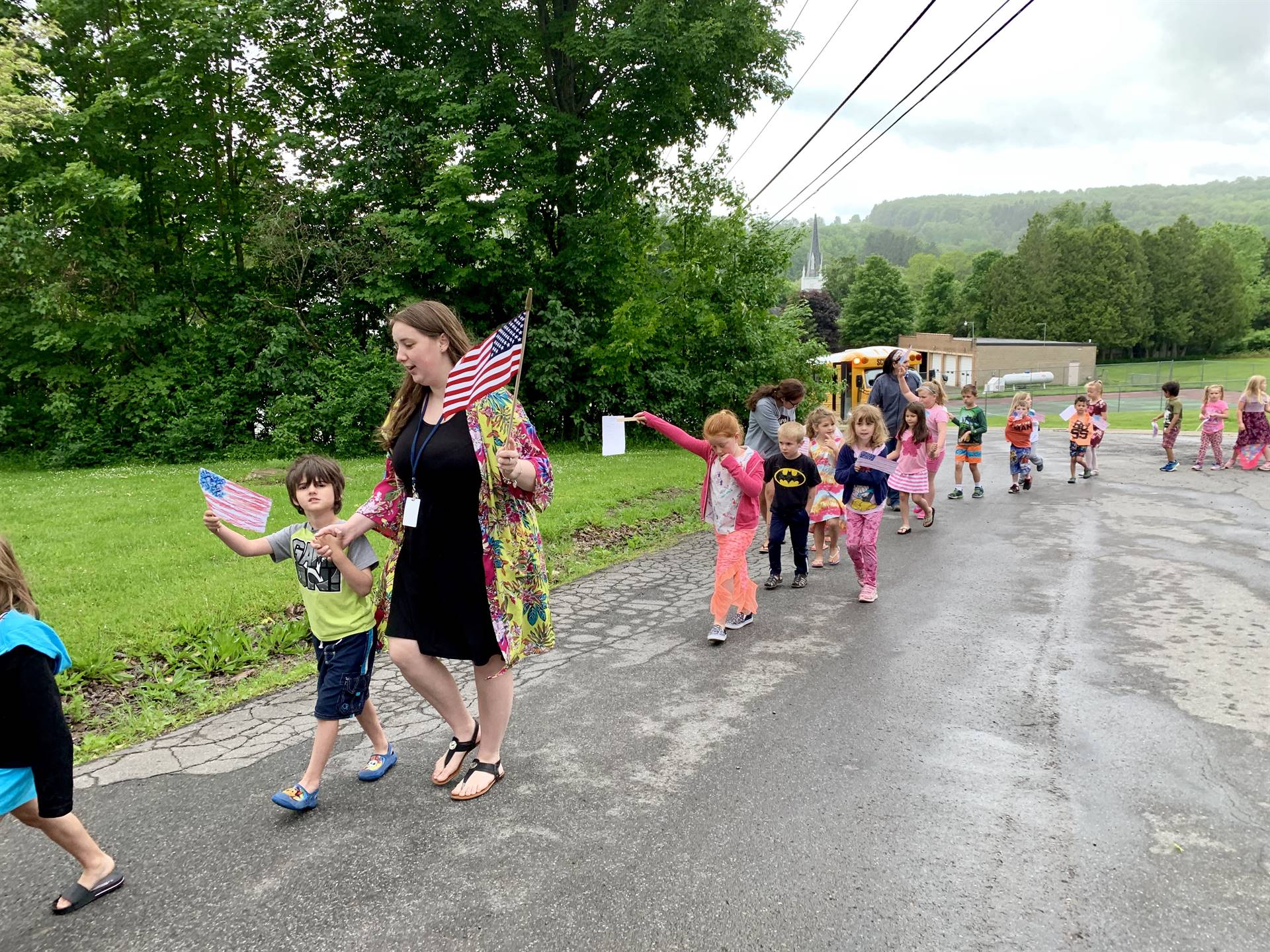 Teachers and students hold up flags and march.