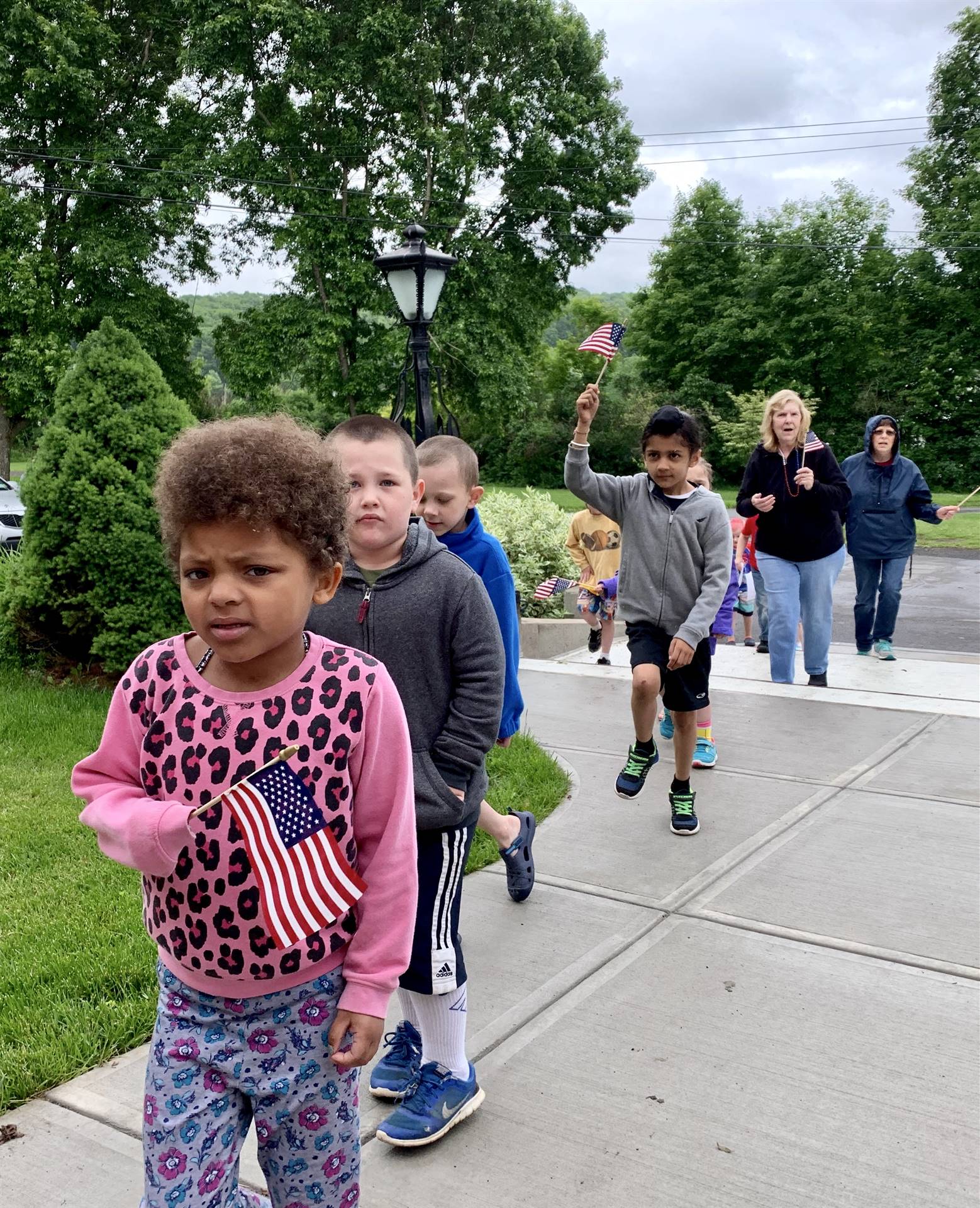 students and staff march in flag day parade.