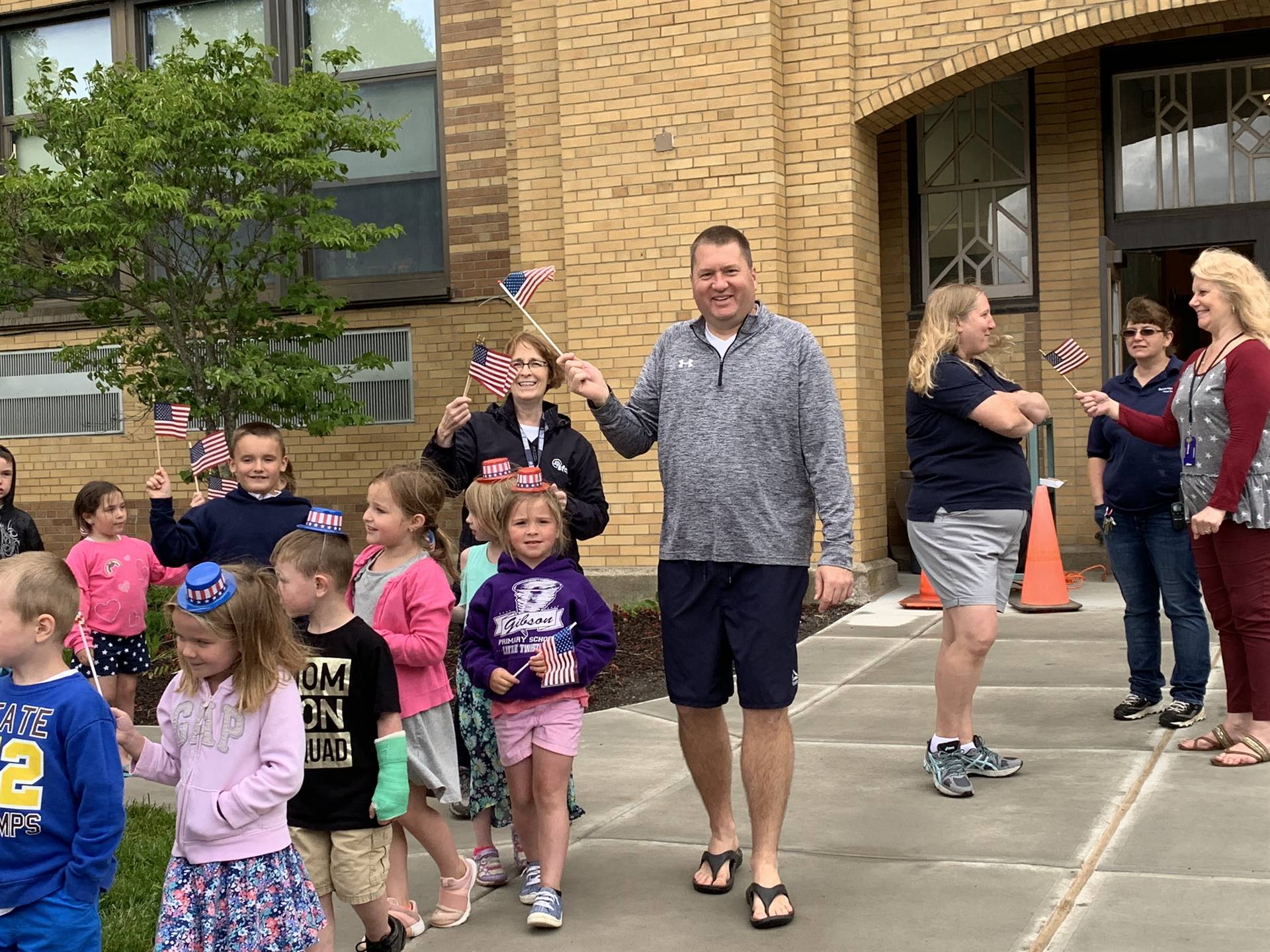 students and staff march in flag day parade.