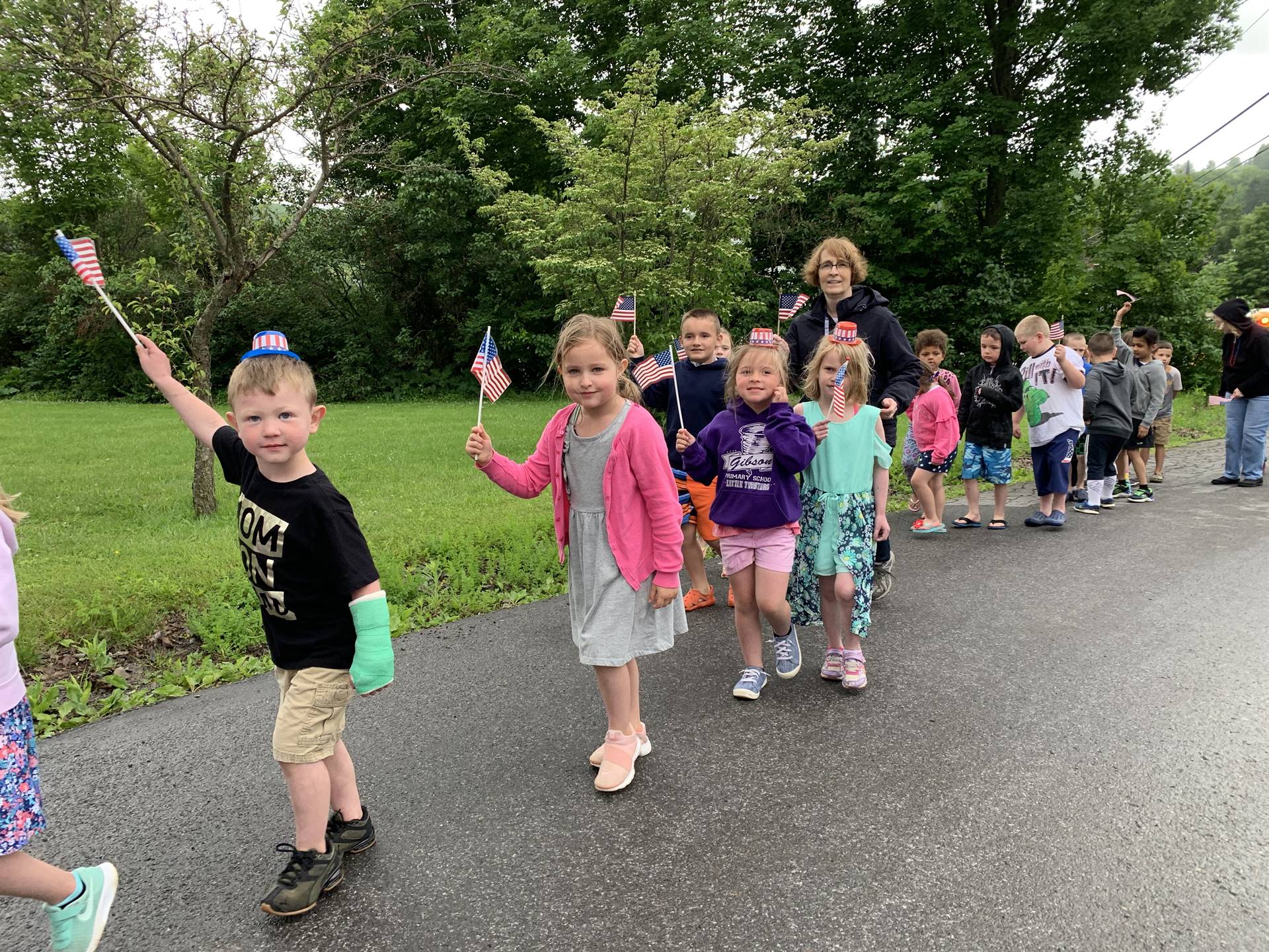 students and staff march in flag day parade.