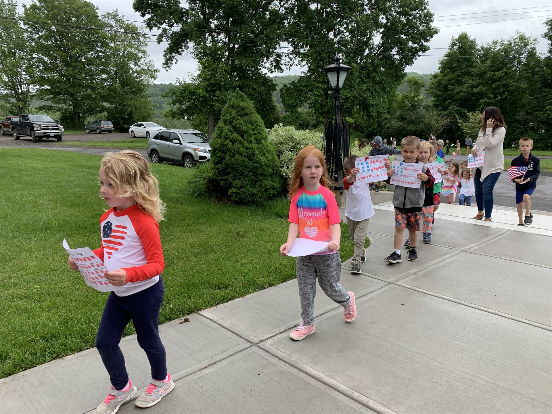 students and staff march in flag day parade.