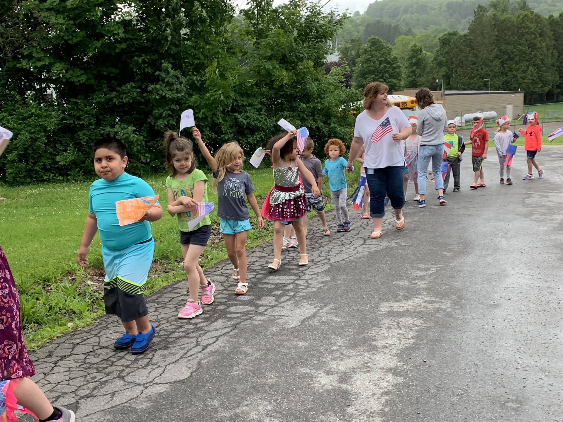 students and staff march in flag day parade.