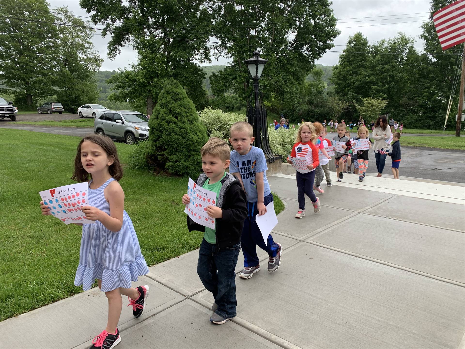 students and staff march in flag day parade.