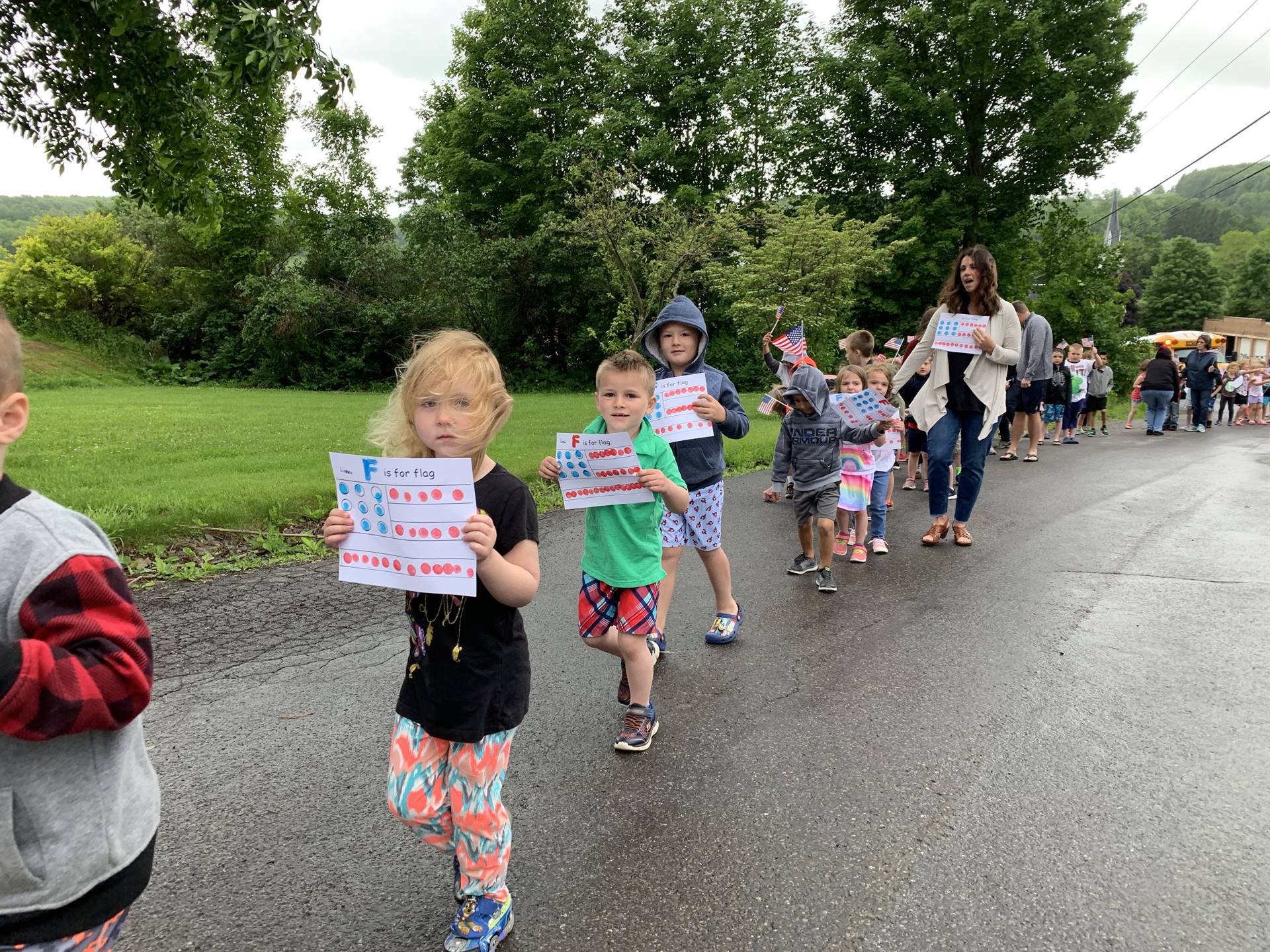 students and staff march in flag day parade.