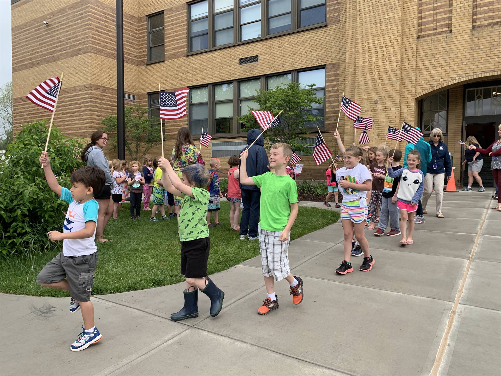 students and staff march in flag day parade.