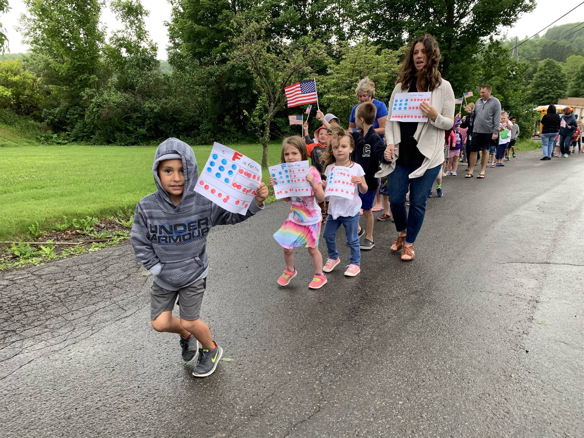 students and staff march in flag day parade.