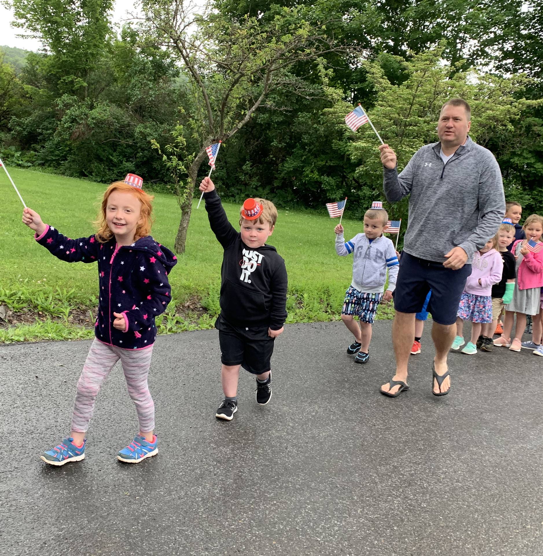 students and staff march in flag day parade.