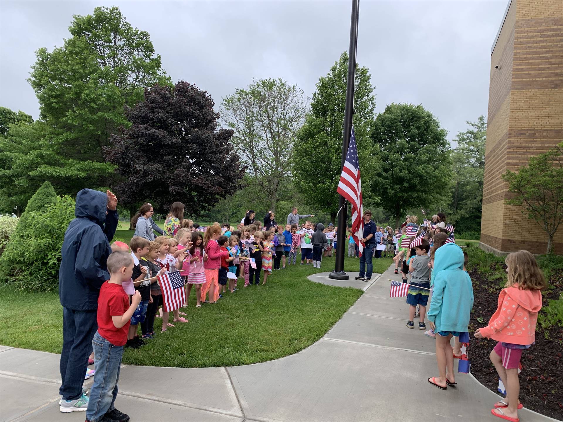 Students and staff around the flag pole.
