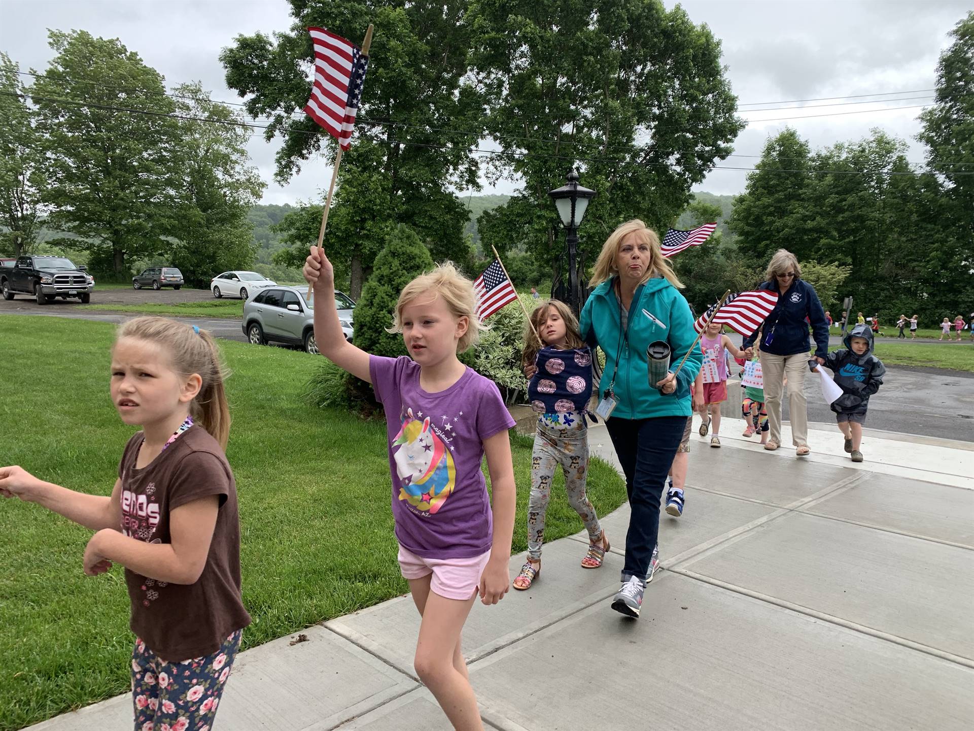 students and staff march in flag day parade.