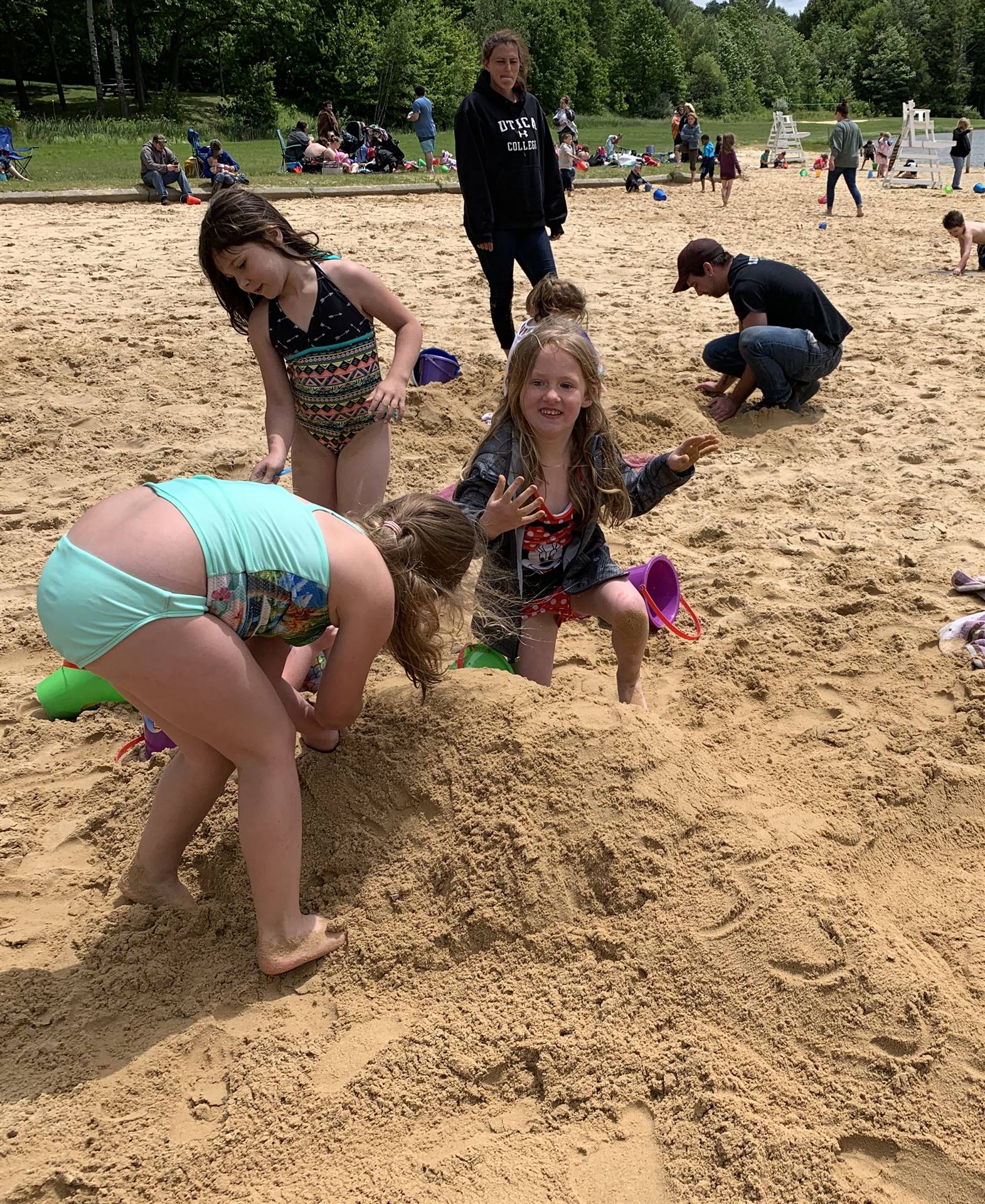 3 students building in the sand.