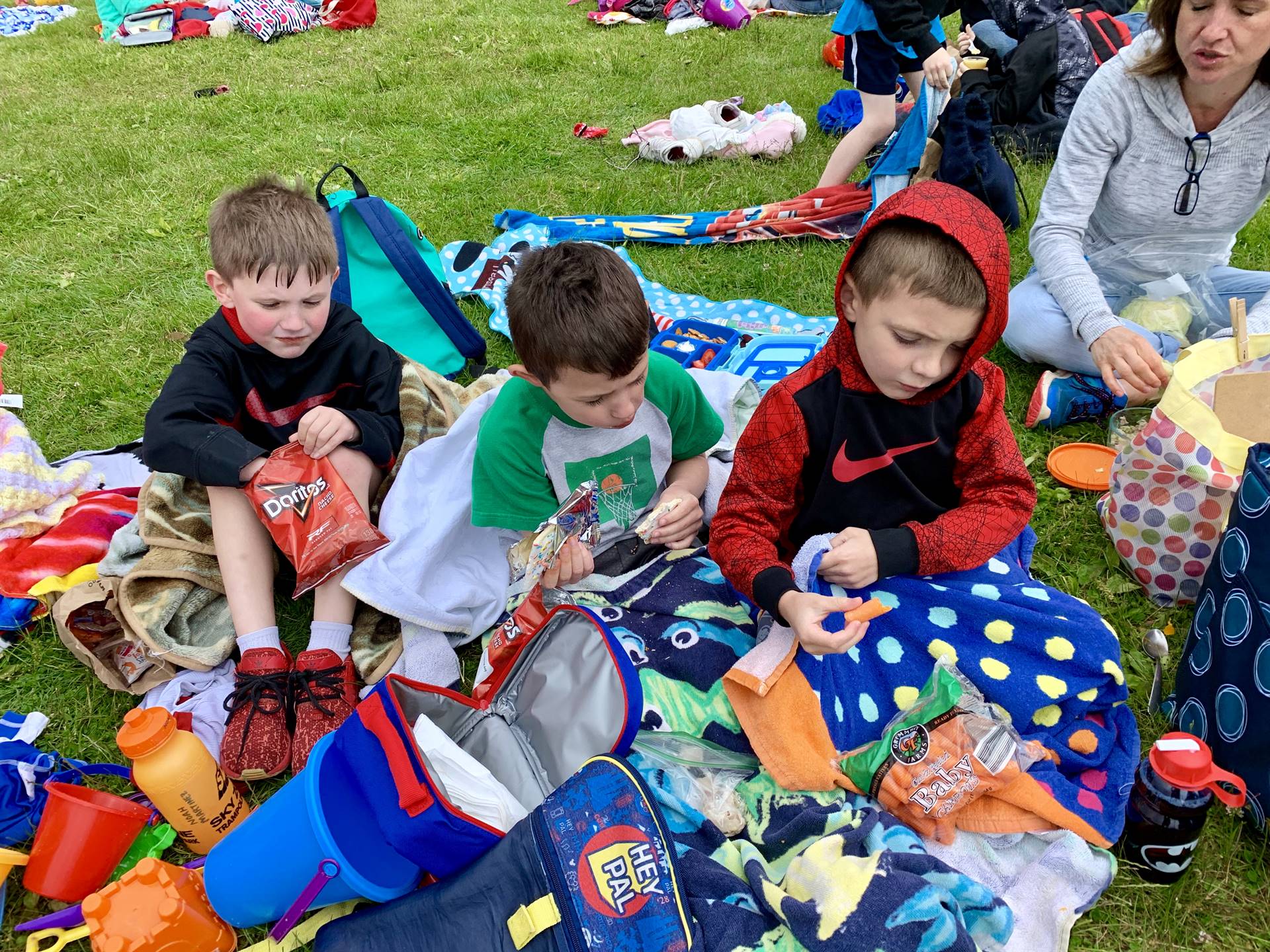 3 students eat a picnic lunch.