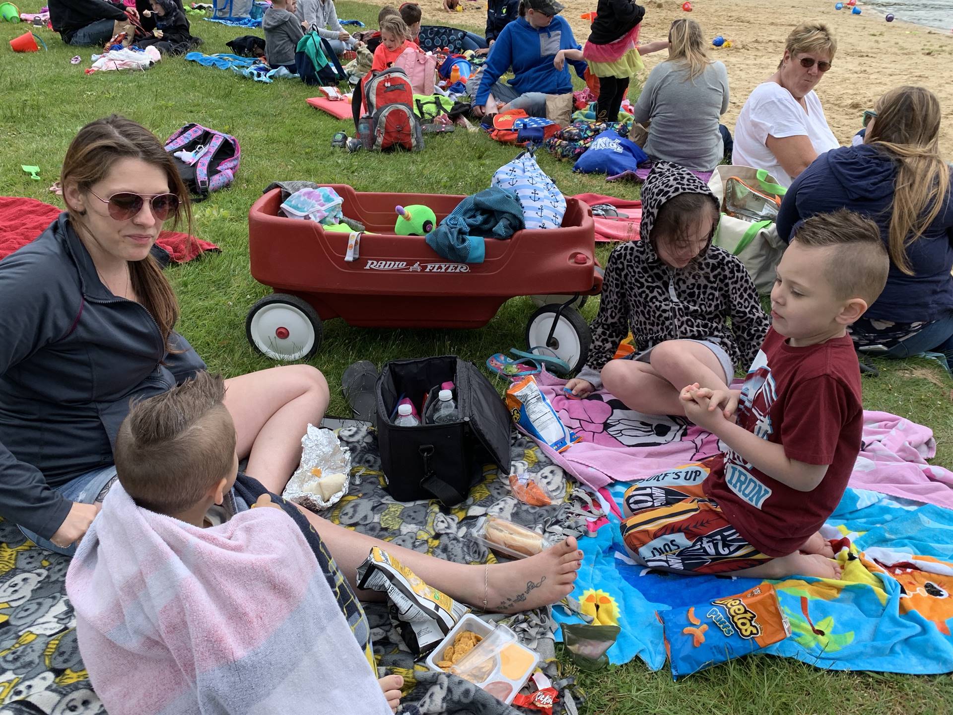 A family of 4 eats a picnic lunch.