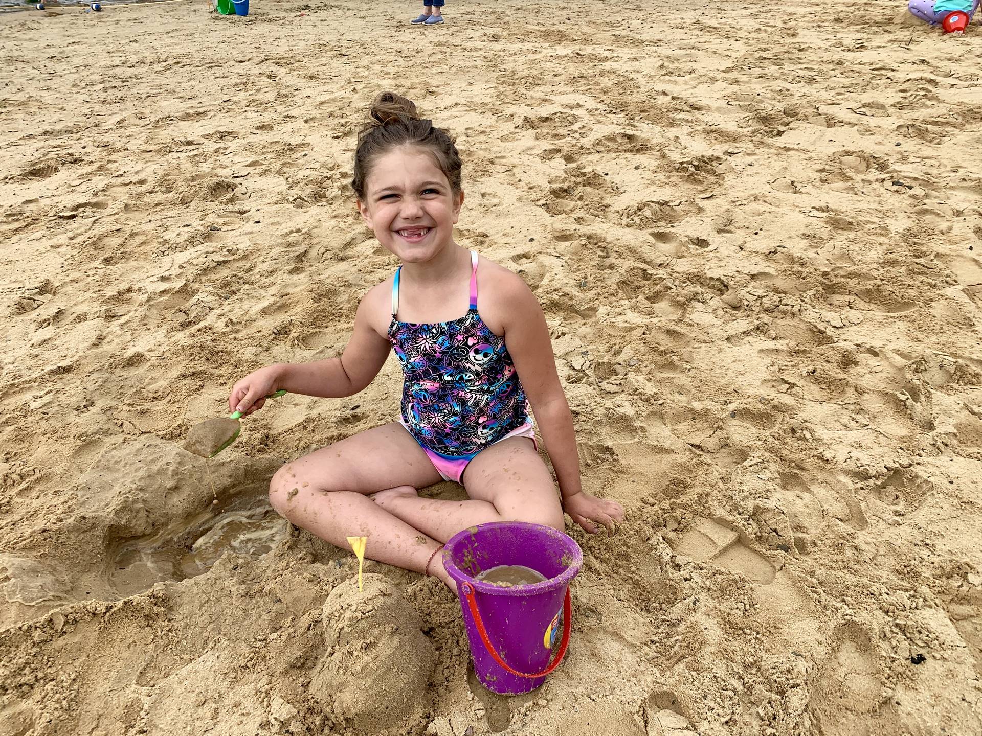 A student plays in sand.