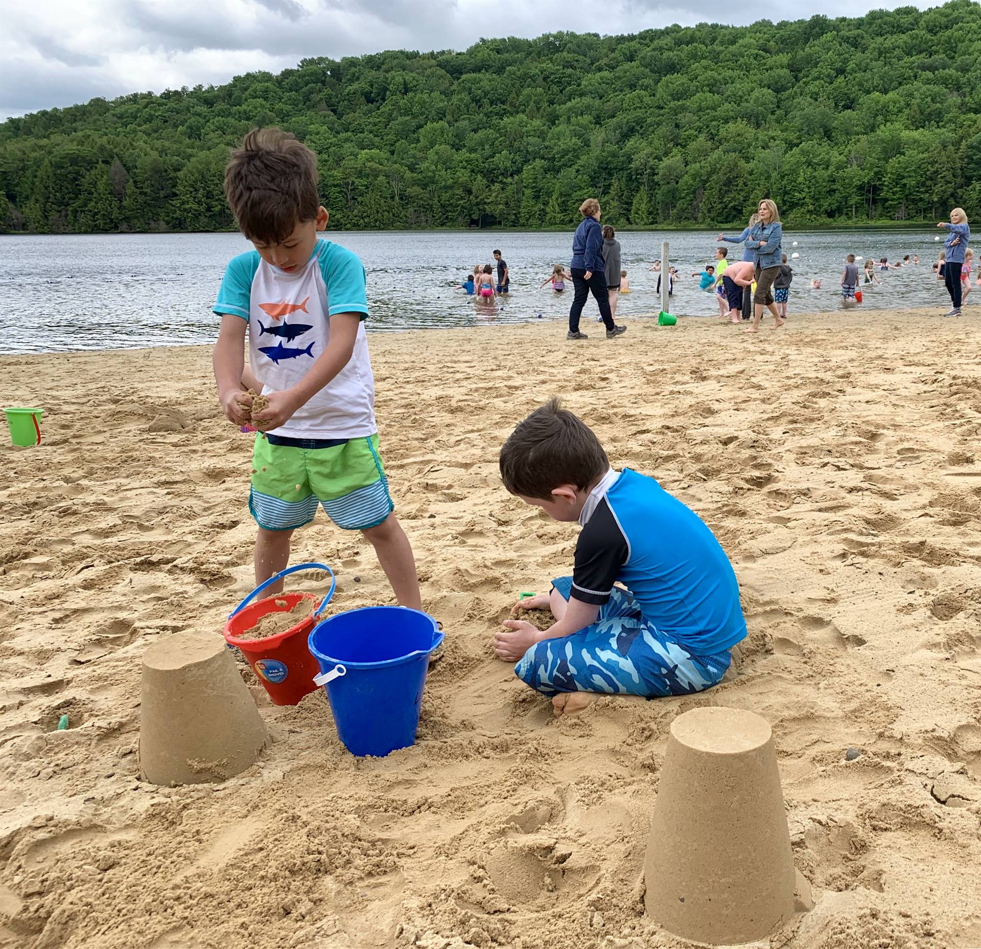 2 students play in sand.