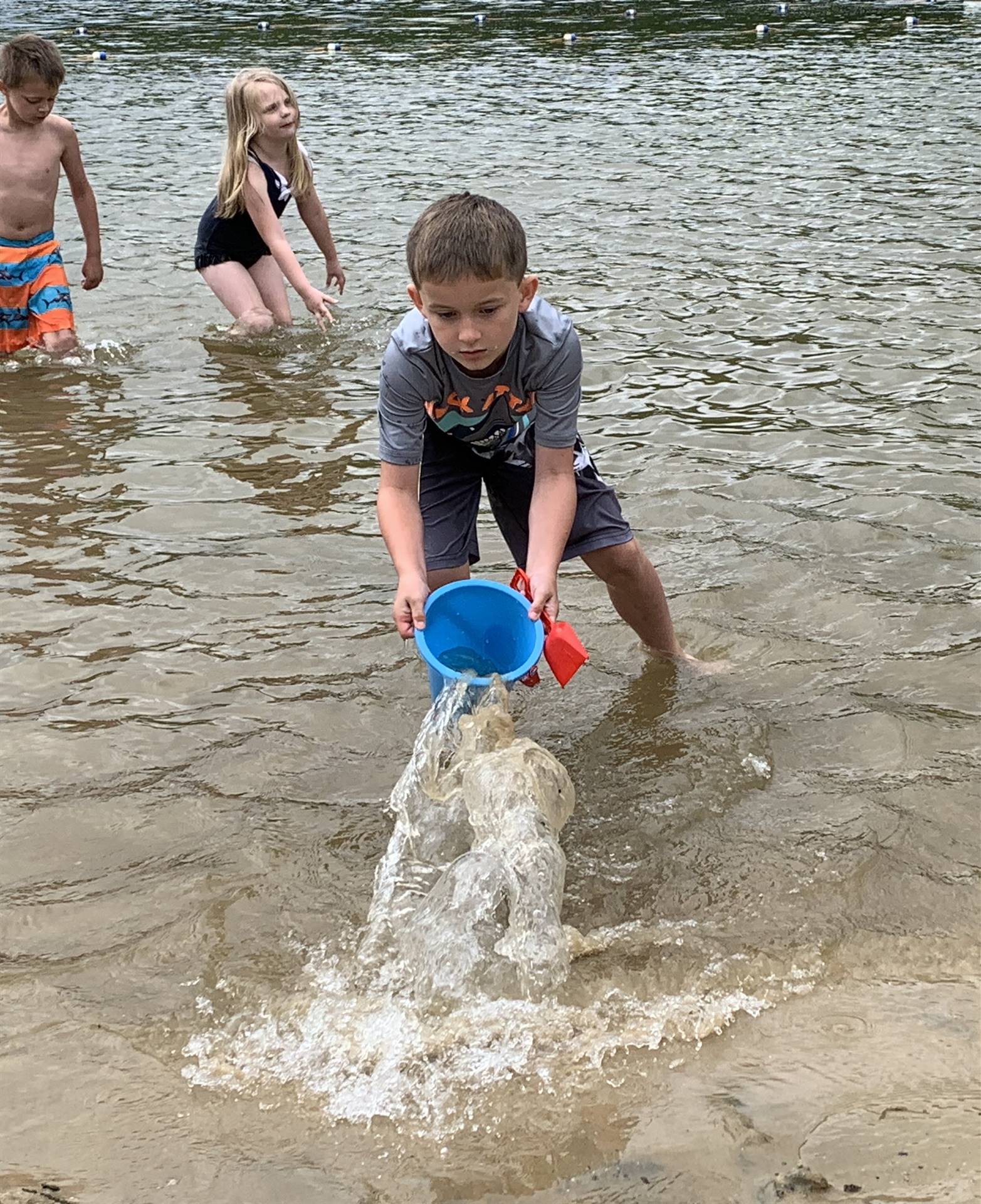 A student dumps water out of his bucket.