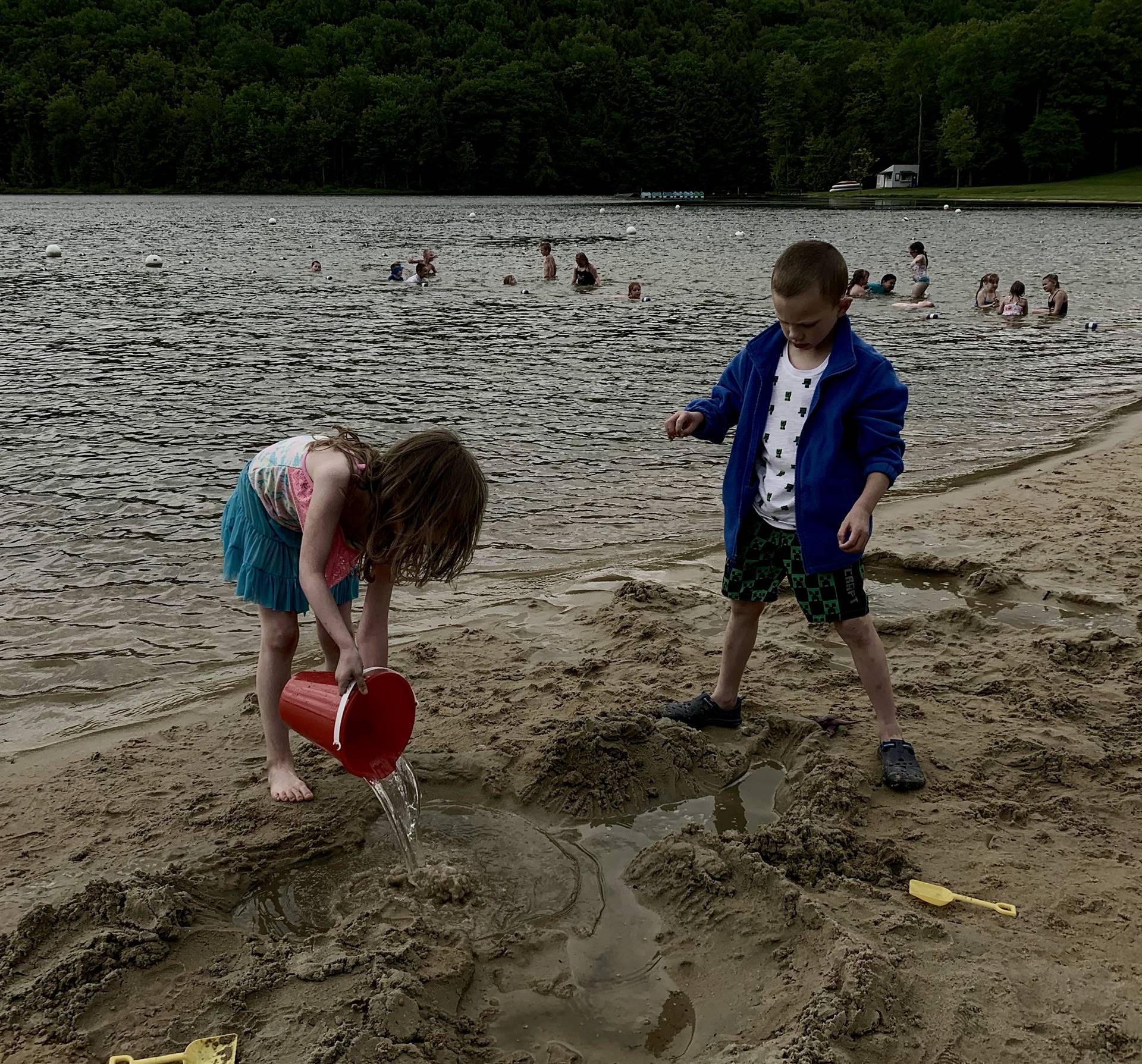 2 students play in sand.