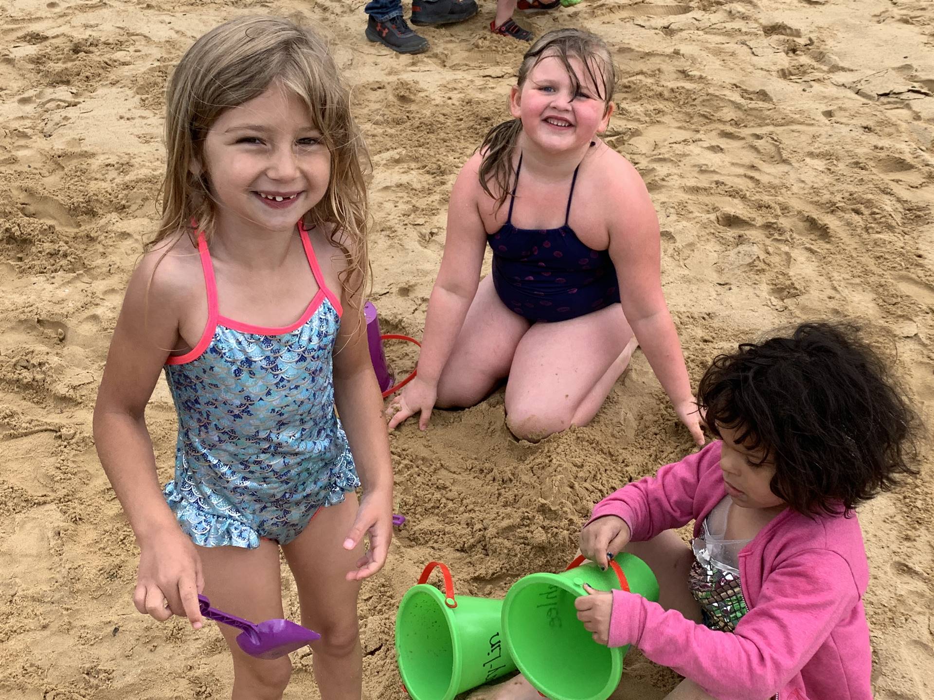 3 students in sand.