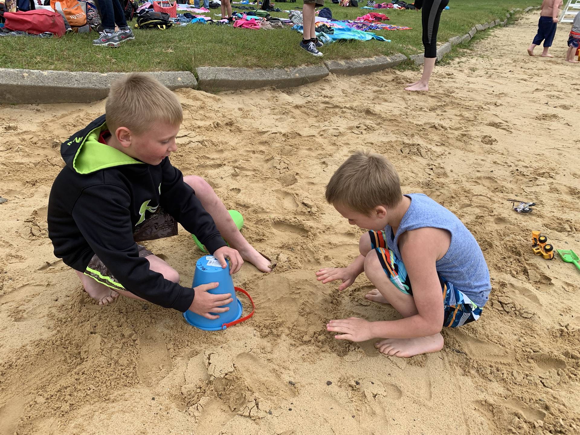 2 students play in sand.