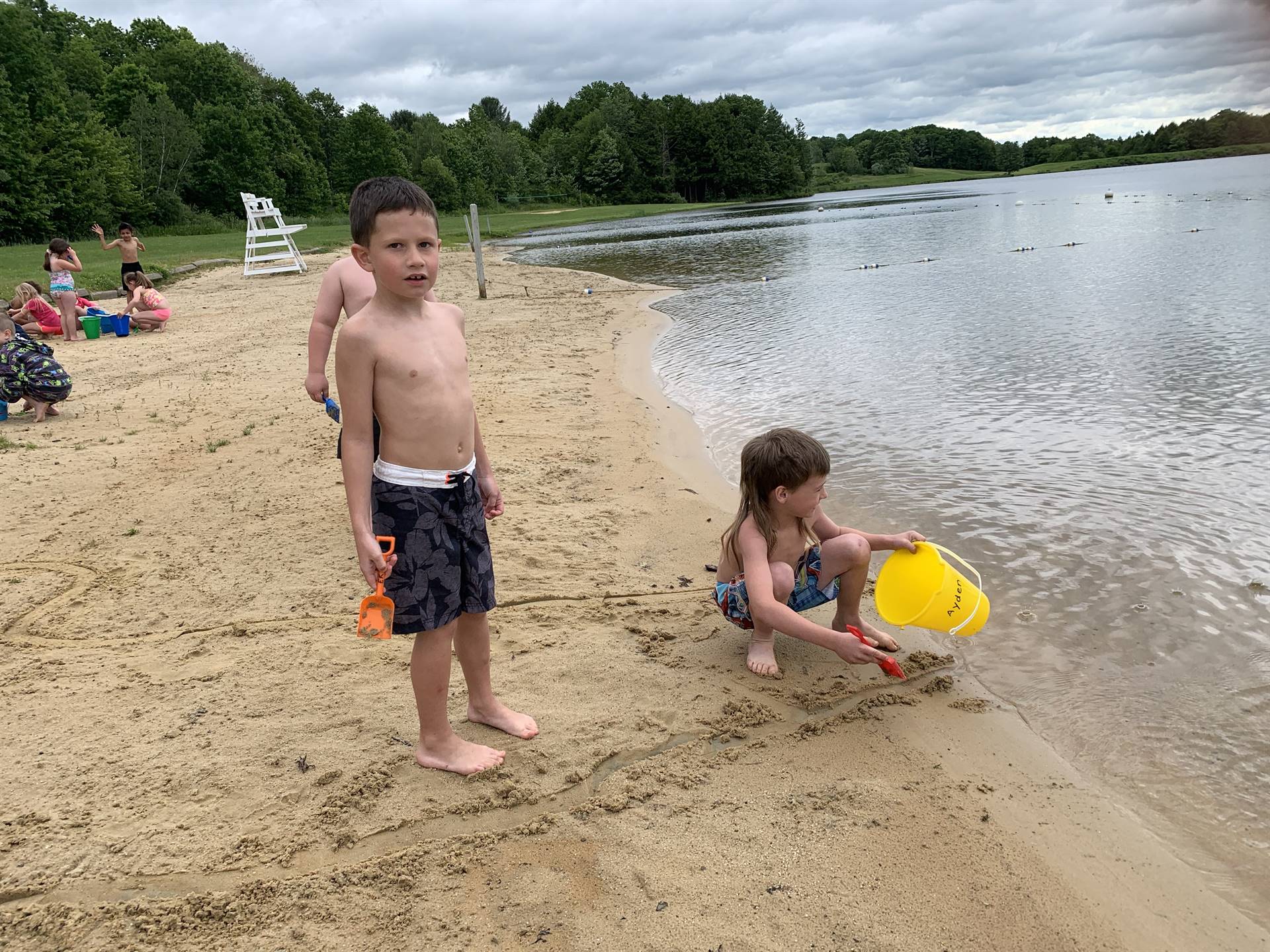 2 students play in sand.