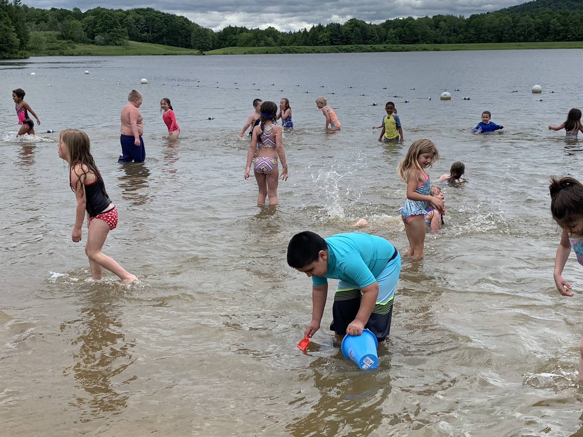 Students play in water and fill buckets with water.