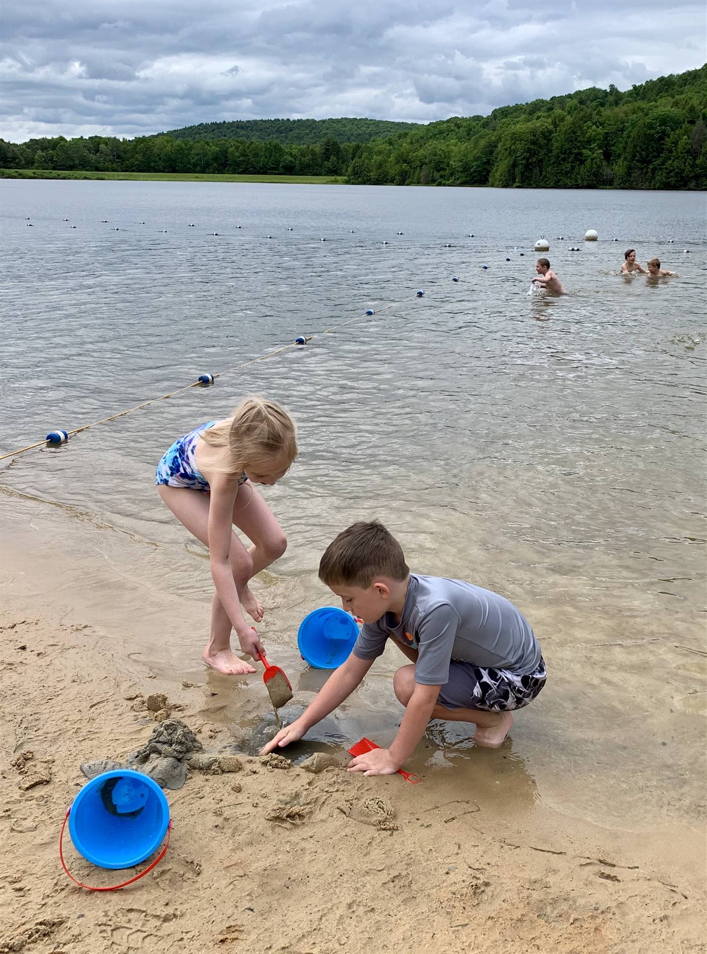 2 students play in sand.