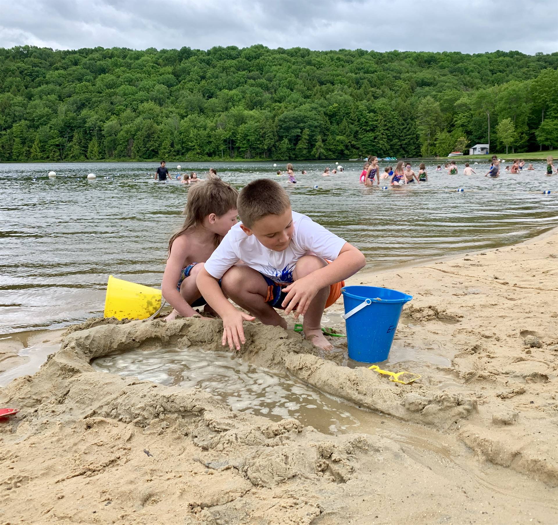 2 students play in sand.