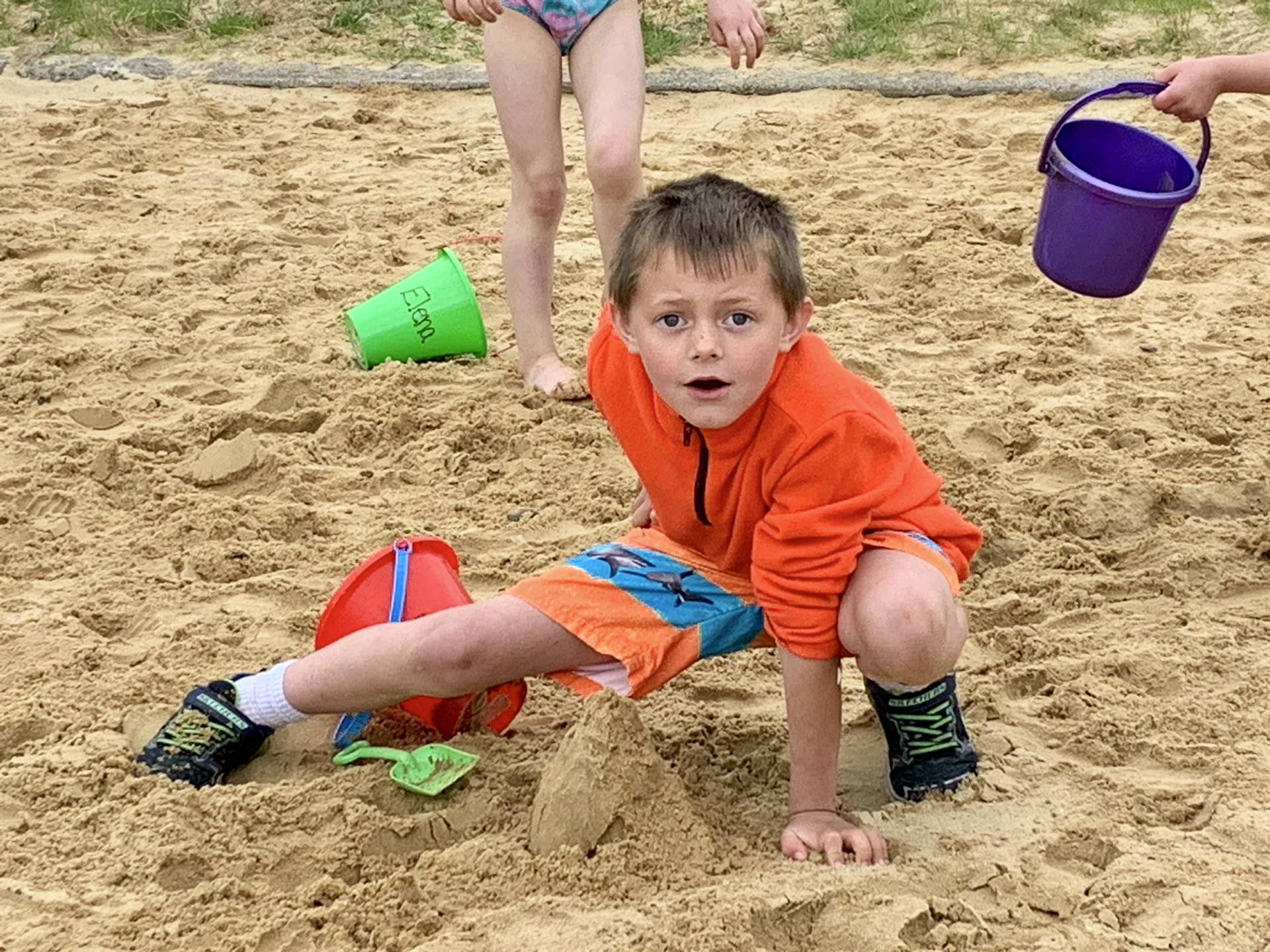 A student shows off a sand castle.